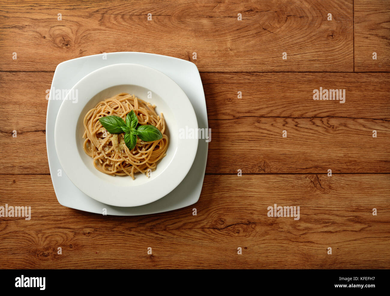 Tutto il frumento spaghetti con parmigiano e foglia di basilico - primo piano Foto Stock