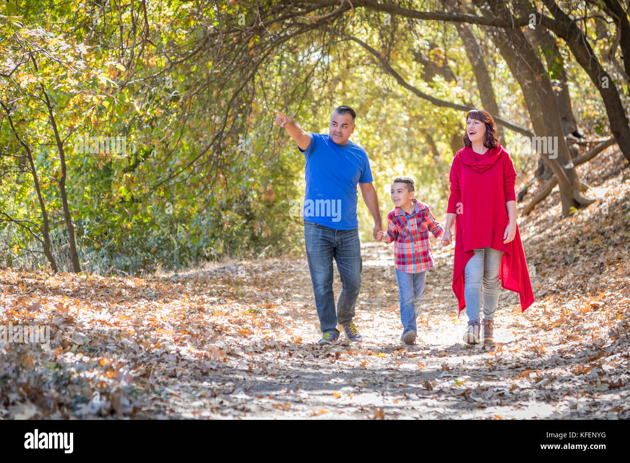 Gara di misto e caucasici famiglia ispanica facendo una passeggiata al parco. Foto Stock