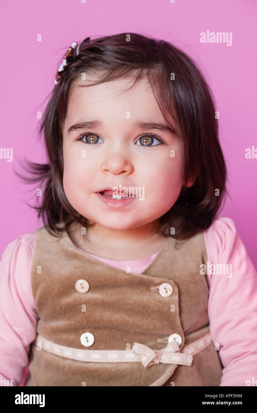 Carino, bello e felice bambina toddler ritratto sorridente, che mostra due denti carino in fondo. 18 o diciotto mesi di età / Bimbo Baby ragazza sorridente Foto Stock