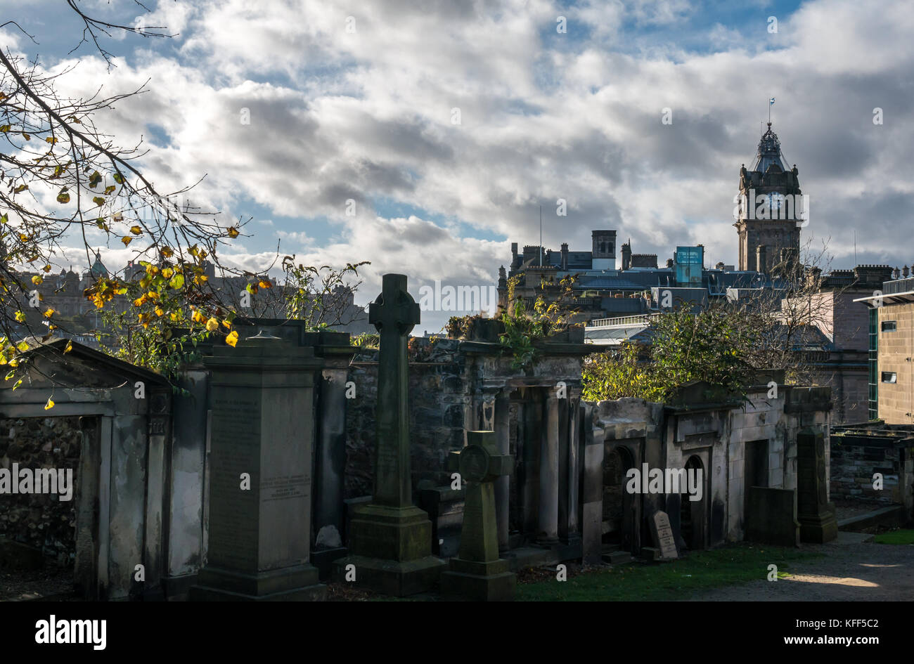 Lapidi e mausolei in Old Calton sepoltura cimitero, Edimburgo, Scozia, Regno Unito, e vista del centro città con Balmoral Hotel torre dell orologio Foto Stock