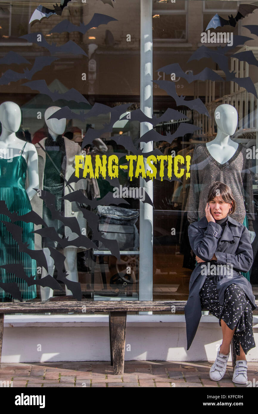 Londra, Regno Unito. 28 ott 2017. Fang-tastic - un negozio lavoratore prende una pausa al di fuori del suo negozio di moda in Northcote Road. Case e negozi sono decorate in preparazione per la festa di Halloween. Londra 28 Ott 2017. Credito: Guy Bell/Alamy Live News Foto Stock