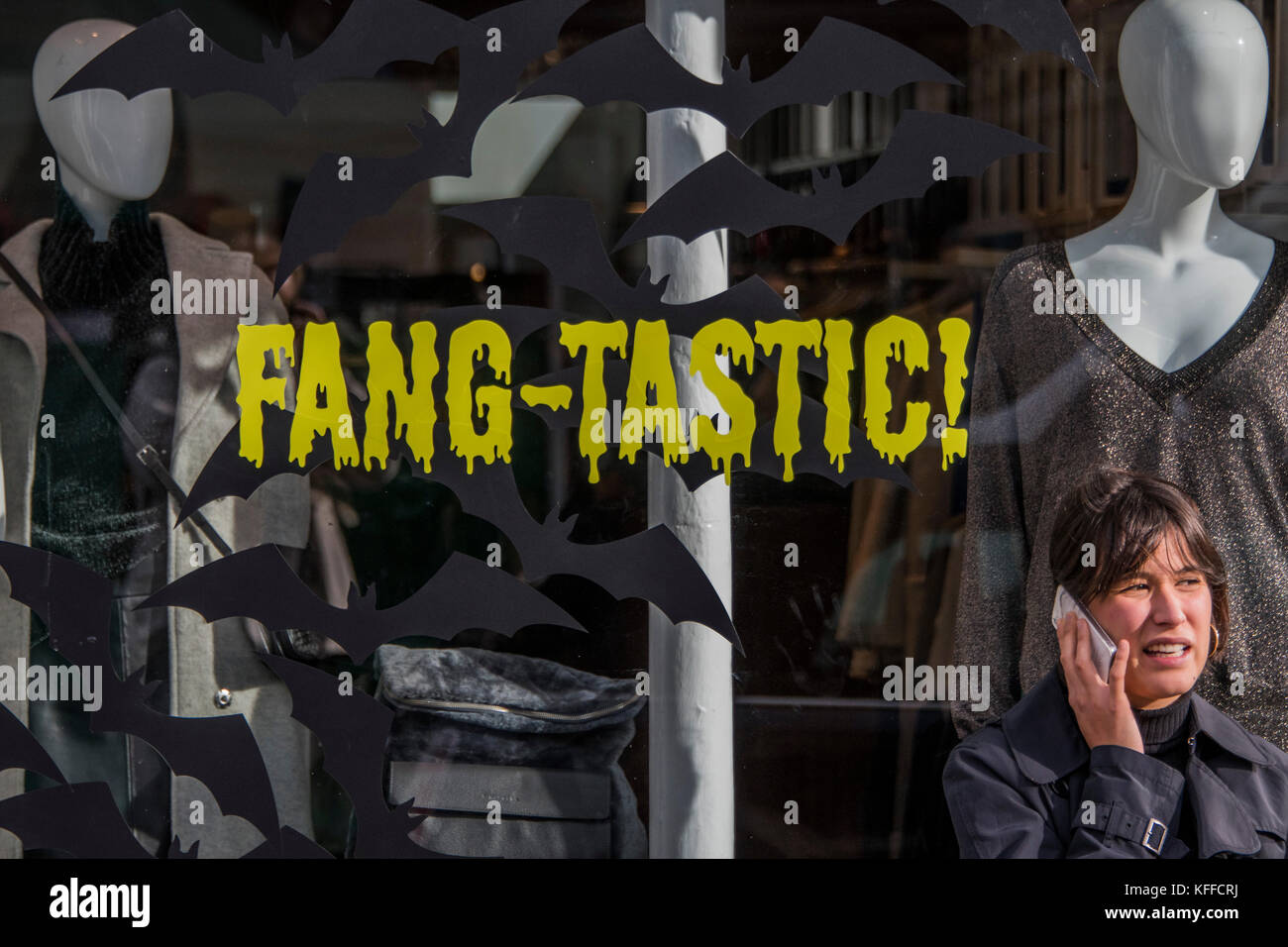 Londra, Regno Unito. 28 ott 2017. Fang-tastic - un negozio lavoratore prende una pausa al di fuori del suo negozio di moda in Northcote Road. Case e negozi sono decorate in preparazione per la festa di Halloween. Londra 28 Ott 2017. Credito: Guy Bell/Alamy Live News Foto Stock