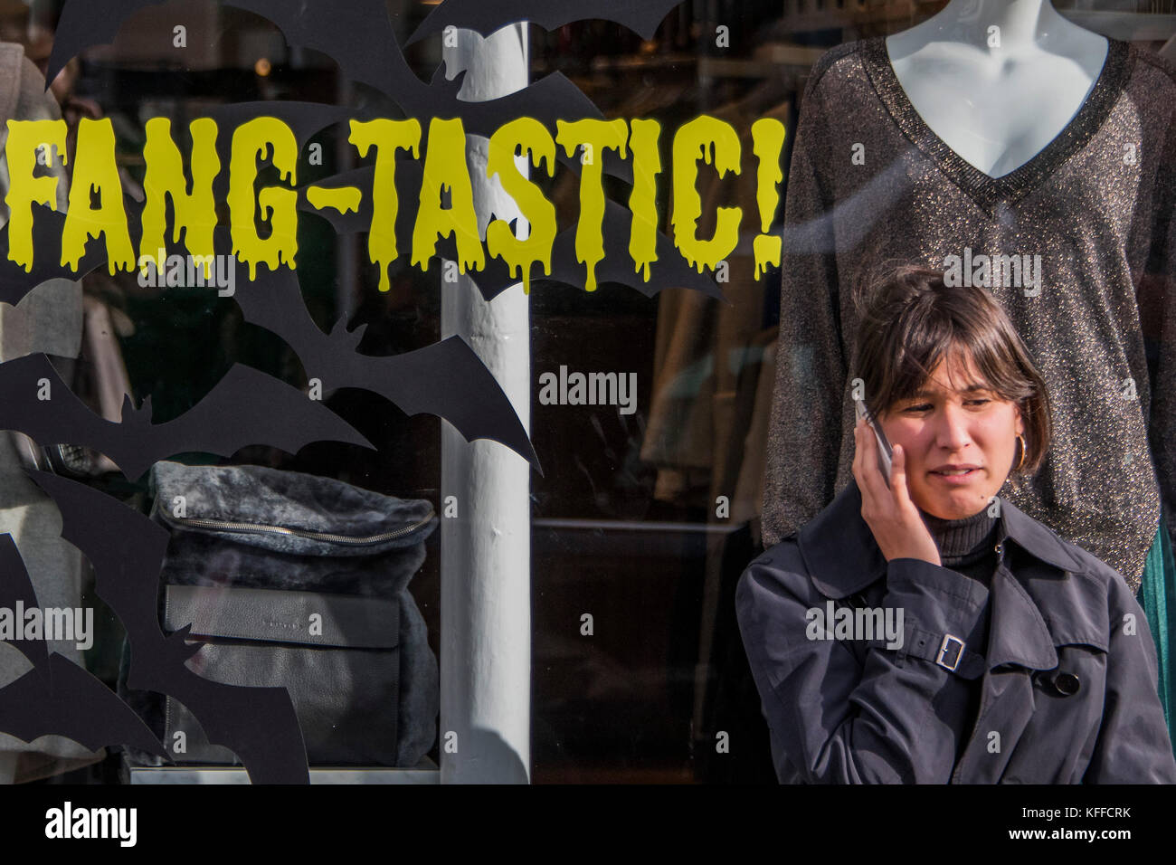 Londra, Regno Unito. 28 ott 2017. Fang-tastic - un negozio lavoratore prende una pausa al di fuori del suo negozio di moda in Northcote Road. Case e negozi sono decorate in preparazione per la festa di Halloween. Londra 28 Ott 2017. Credito: Guy Bell/Alamy Live News Foto Stock
