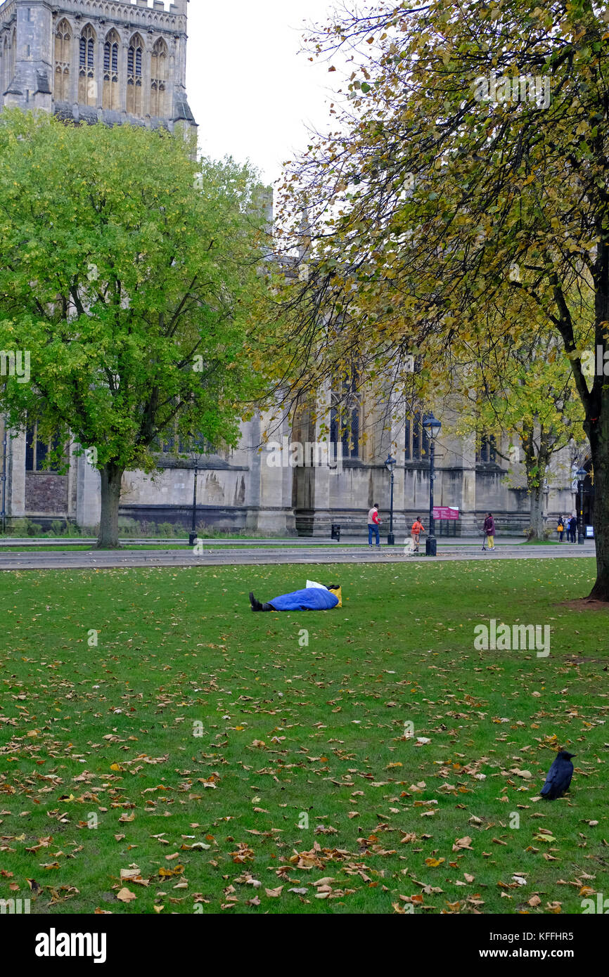 Bristol, Regno Unito. 28 ottobre, 2017. Una persona senza dimora dorme sul College Green, vicino alla cattedrale e al consiglio comunale di uffici. Un recente National Audit Office, relazione che ha utilizzato i dati raccolti in Bristol e sette altri enti locali, suggerisce che il numero delle traversine ruvida in Inghilterra è aumentato del 134% tra il 2010 e il 2016. Keith Ramsey/Alamy Live News Foto Stock