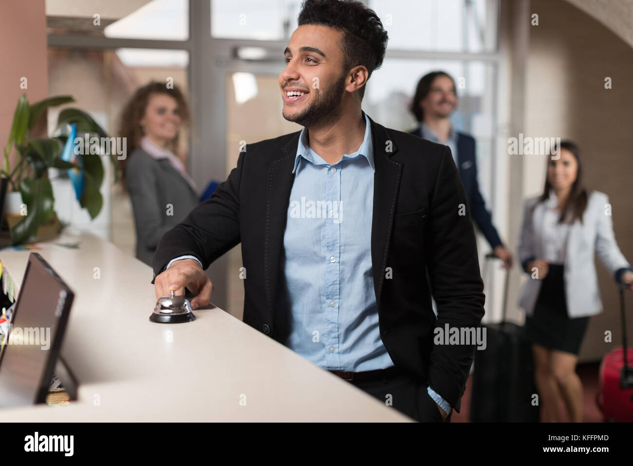 Ispanico uomo d affari di arrivare in hotel in attesa di verificare nel business di registrazione gruppo di persone nella lobby Foto Stock