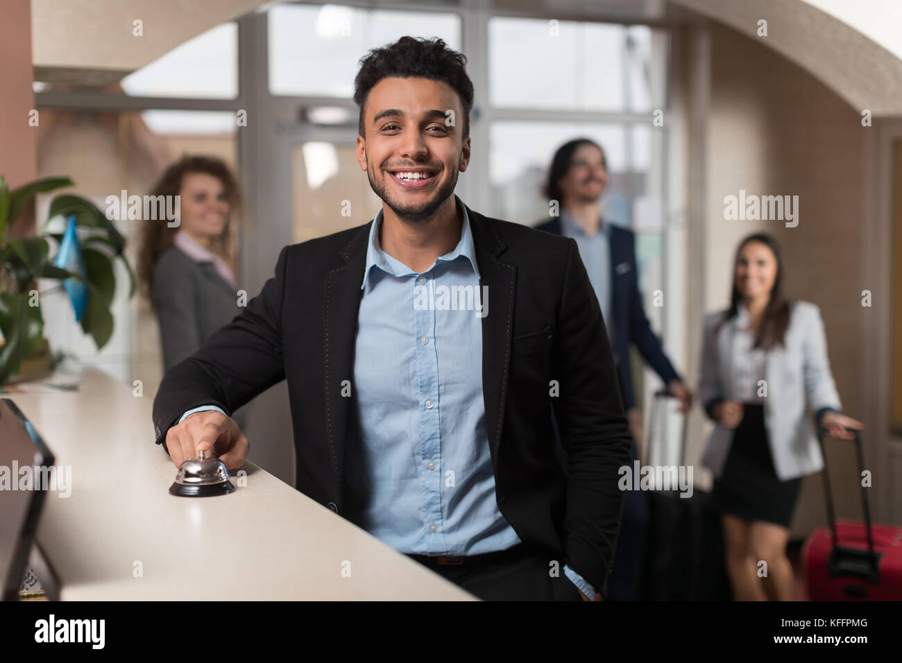 Ispanico uomo d affari di arrivare in hotel in attesa di verificare nel business di registrazione gruppo di persone nella lobby Foto Stock