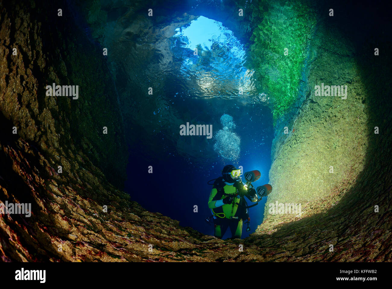 Scuba Diver al l'ingresso della grotta al lago dell'isola susac, mare adriatico, il parco naturale di Lastovo, isola di susac, DALMAZIA, CROAZIA Foto Stock
