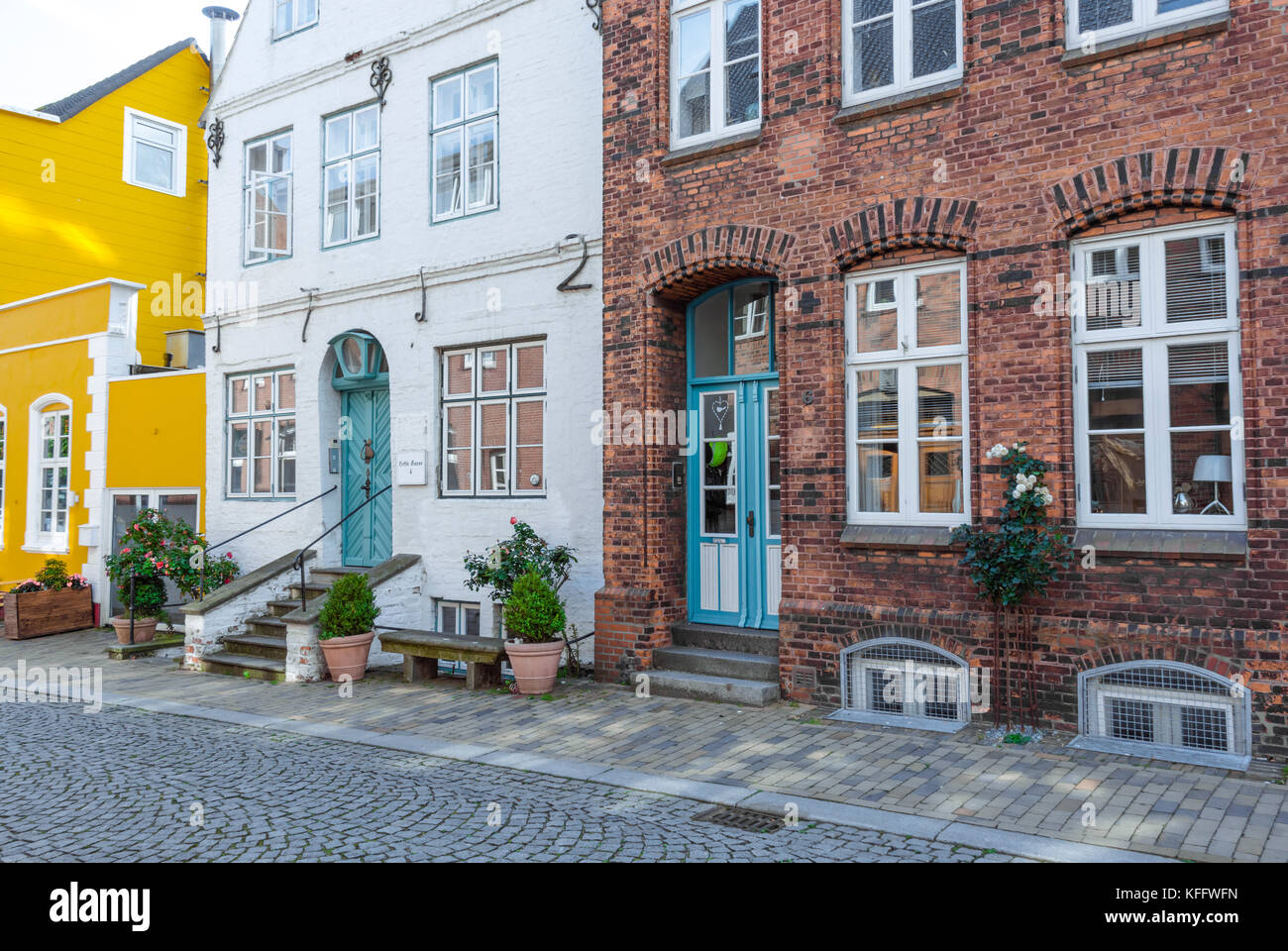 Edificio di mattoni e case con ingresso con scale per la strada nella città costiera di husum al mare del Nord, Germania Foto Stock