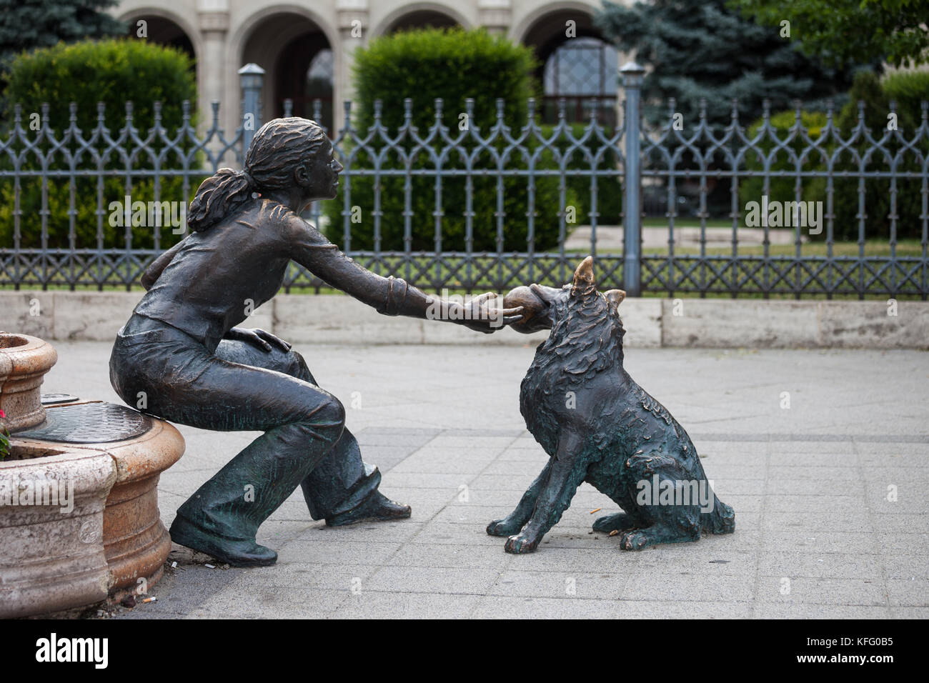 Ragazza con il suo cane, street scultura in bronzo, piazza Vigado, città di Budapest, Ungheria, ragazza giocare con l'animale con la sfera nella sua bocca Foto Stock