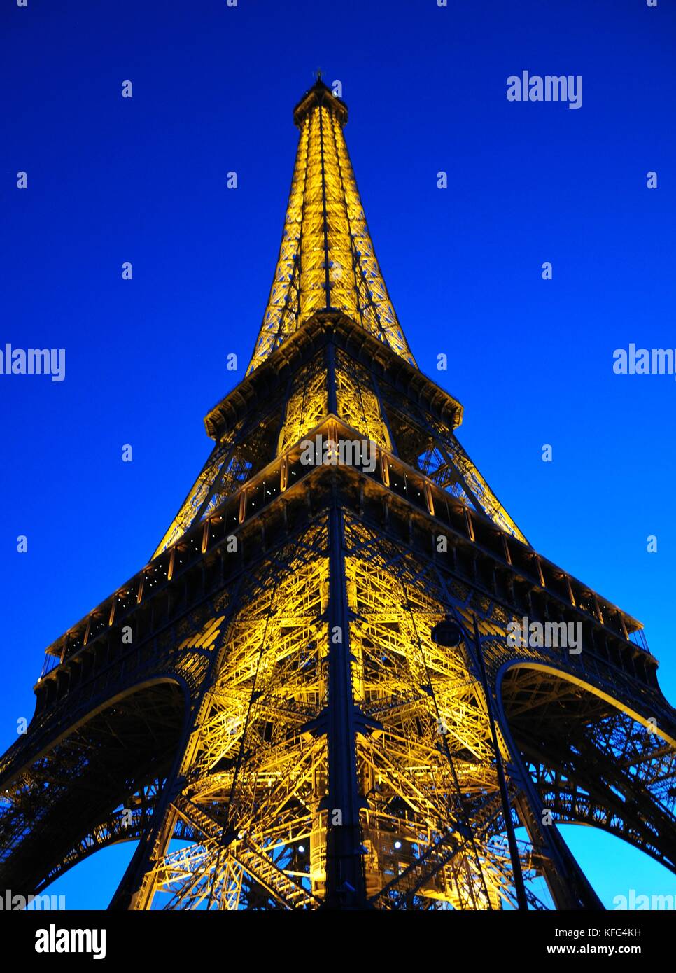Illuminata dalla Torre Eiffel a Parigi Francia al tramonto. famosa ferro artistico lavoro astratto di architettura Foto Stock