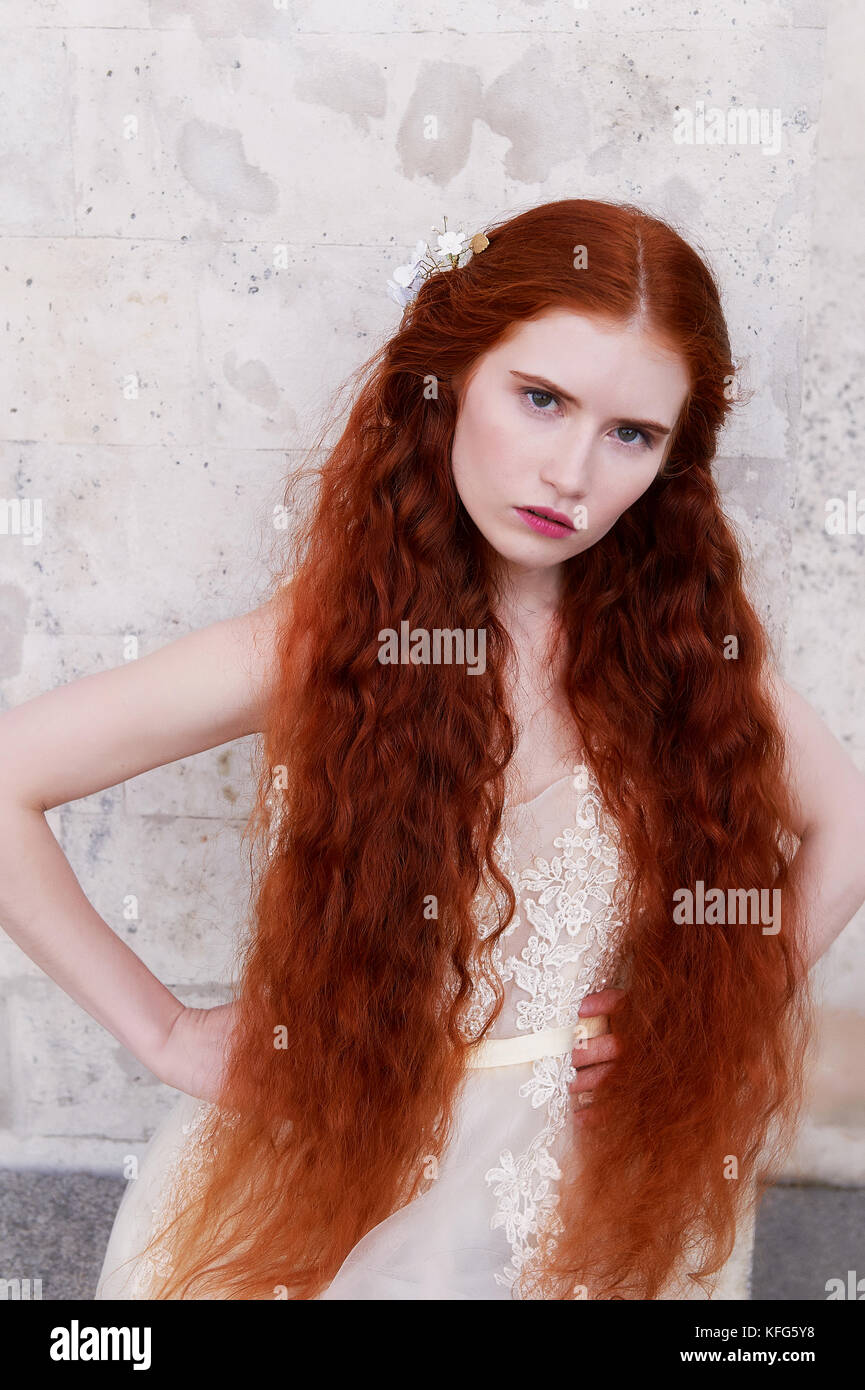 Bellissimi i Capelli rossi ragazza con lunghi capelli ricci in sposa, in un  lungo abito in pizzo.una bellezza naturale Foto stock - Alamy