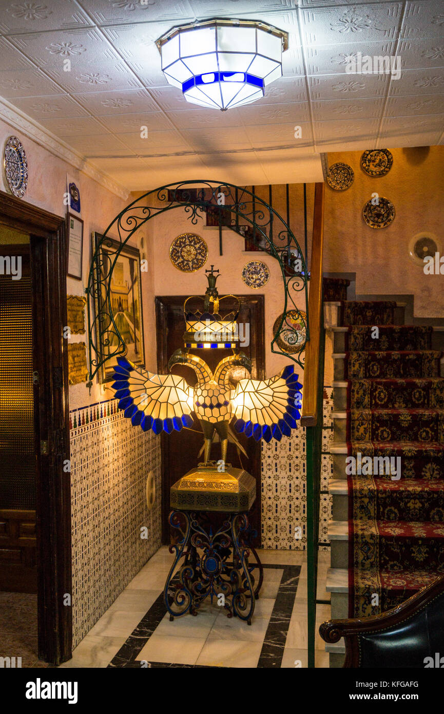 La lobby di Hostal Lima hotel, con lampada a forma di doppio-headed eagle emblema dei monarchi cristiani, Granada, Andalusia Foto Stock