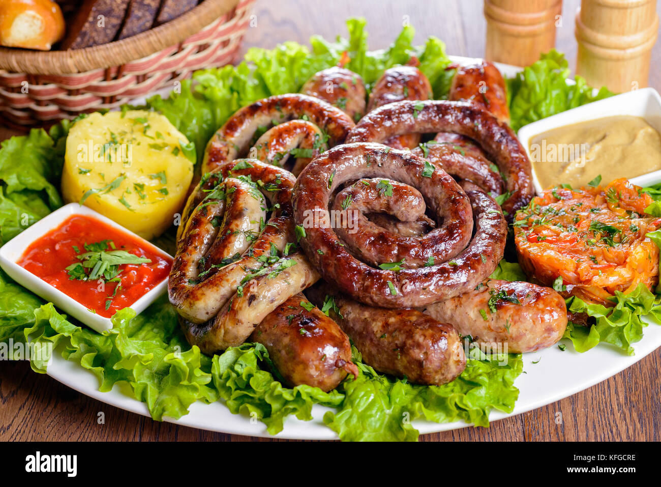 Un assortimento di salsicce bavarese guarnita con verdi e salse Foto Stock