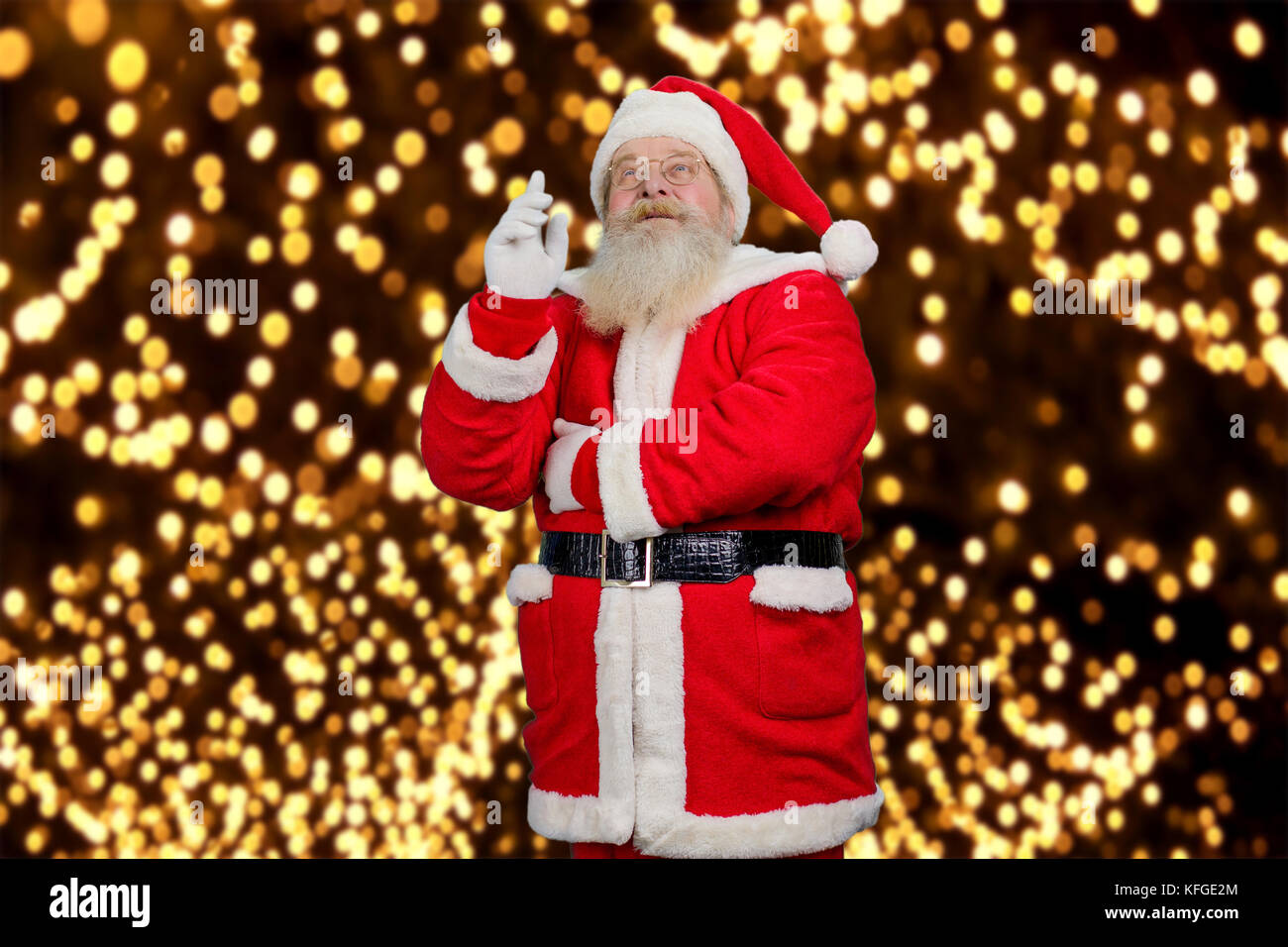 Santa Claus rivolta verso l'alto. vecchio santa claus in costume rosso e hat sollevato inex dito e guardando verso l'alto. Babbo Natale e Anno Nuovo favola. Foto Stock