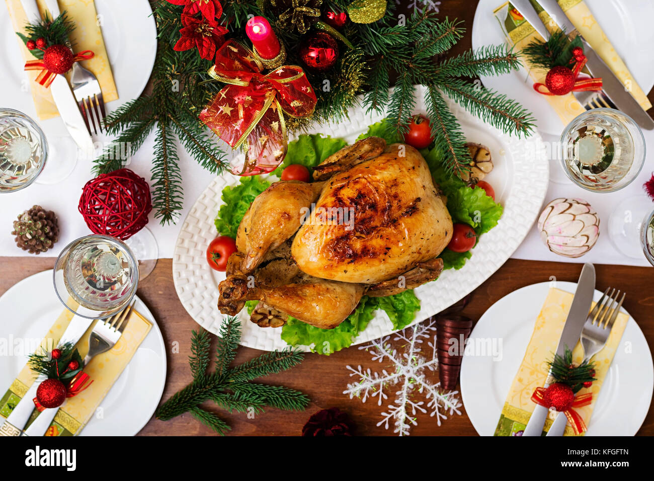 La Turchia al forno o pollo. la tavola del Natale è servita con una Turchia, decorate con colori luminosi tinsel e candele. pollo fritto, tabella. Cena di Natale Foto Stock