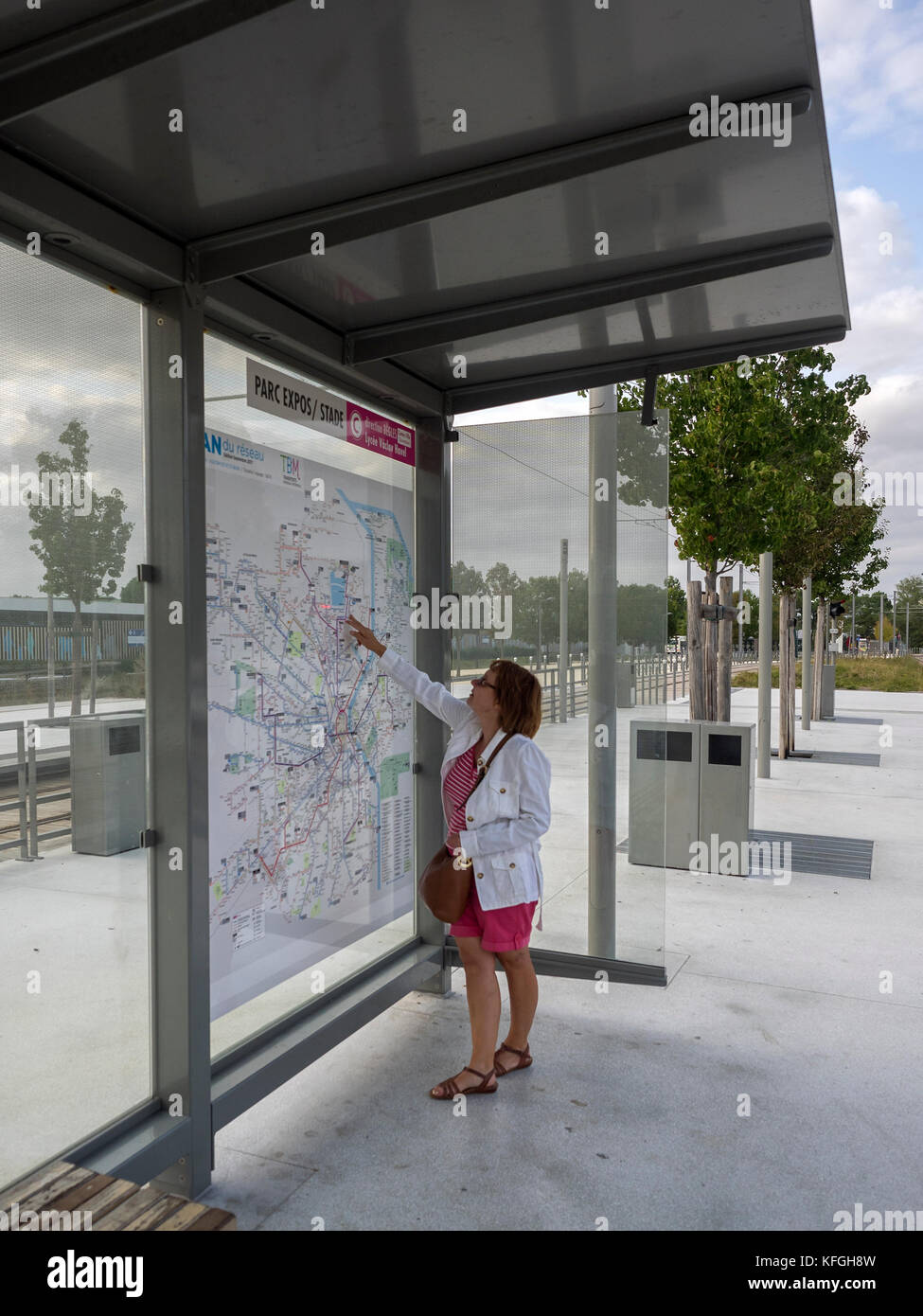 BORDEAUX, FRANCIA - 06 SETTEMBRE 2017: Donna al Tram Stop check route su grande Bordeaux Transport Route Map Foto Stock