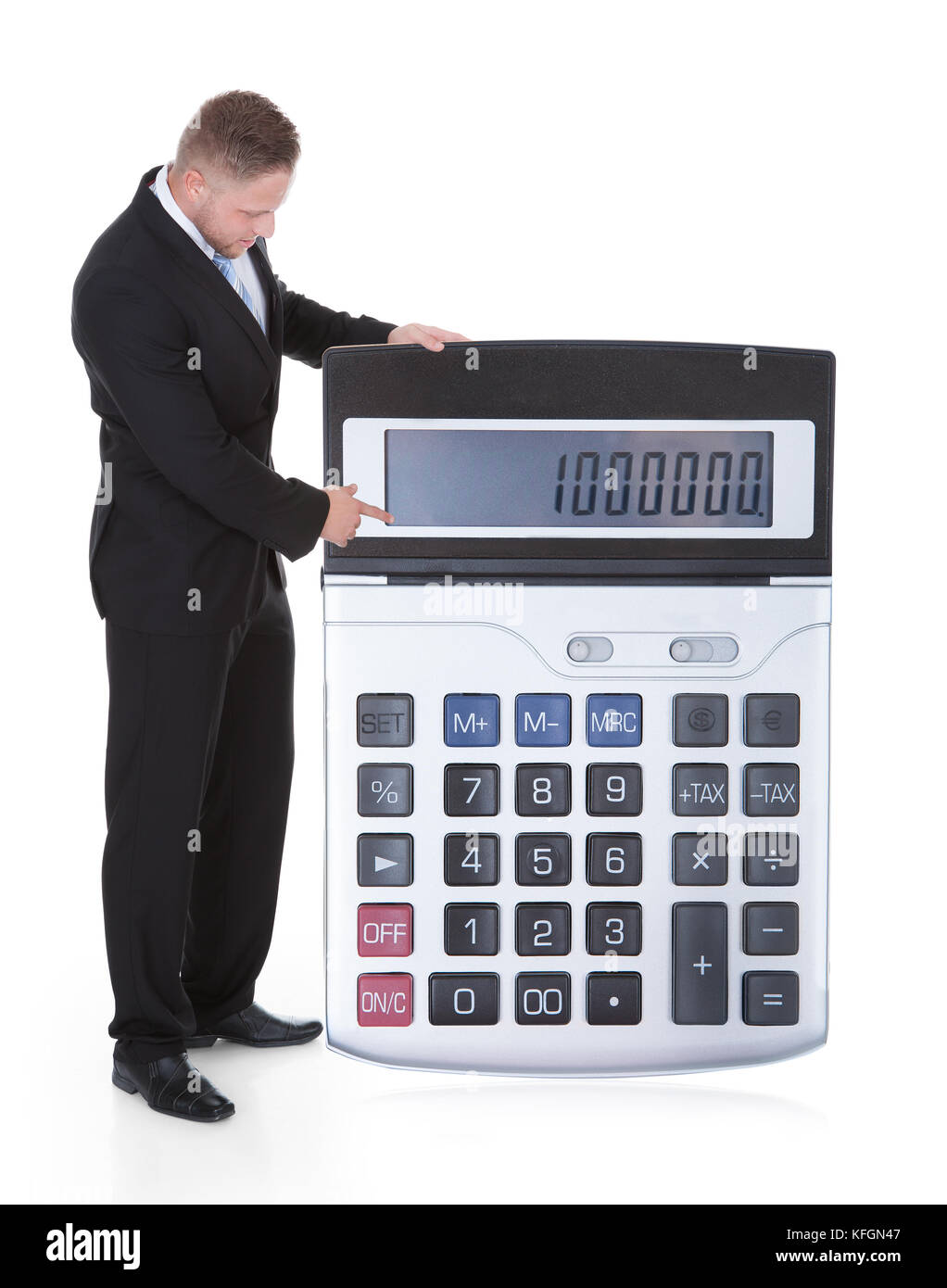 Sorridente imprenditore attraente in una tuta visualizzando un una grande calcolatrice con la tastiera verso la telecamera concettuale immagine finanziaria isolato Foto Stock