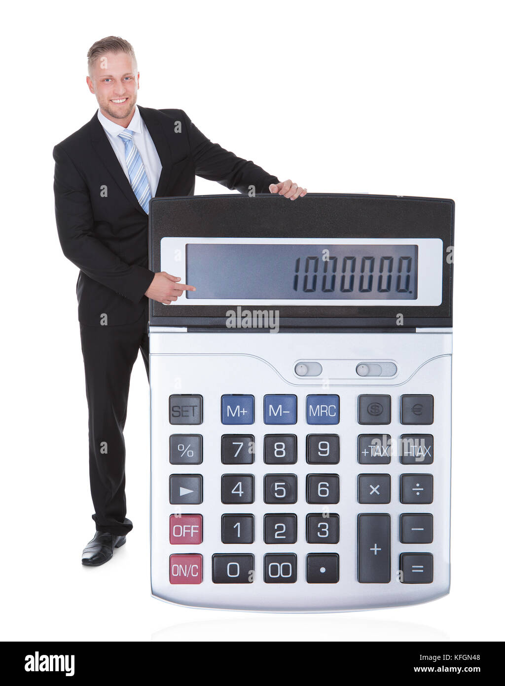Sorridente imprenditore attraente in una tuta visualizzando un una grande calcolatrice con la tastiera verso la telecamera concettuale immagine finanziaria isolato Foto Stock
