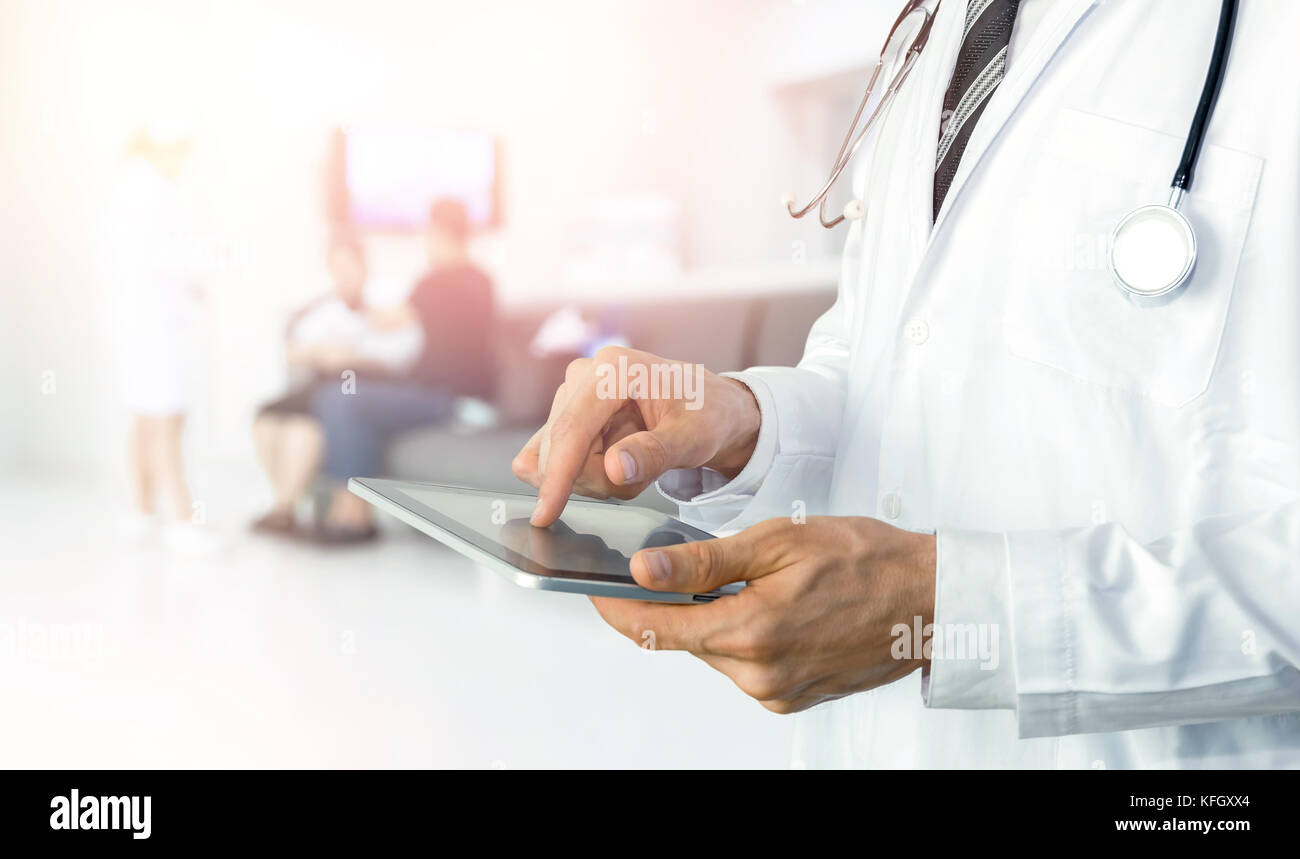 Smart health care internet delle cose e ospedale di gestione dell'automazione di concetto di tecnologia con supporti cartacei. Medico con stetoscopio utilizzando tablet per ri Foto Stock