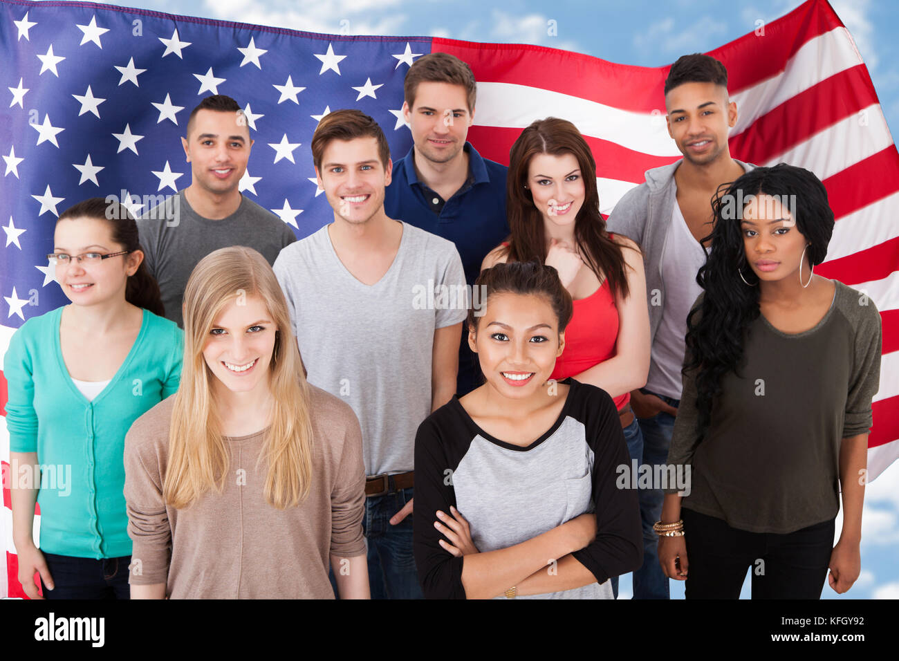 Happy Multi-etnia Gruppo di persone in piedi di fronte alla bandiera americana Foto Stock