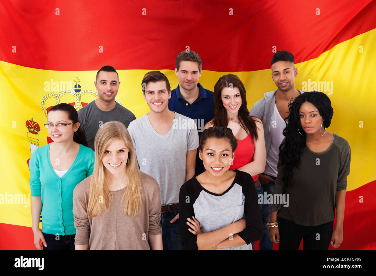 Happy Multi-etnia Gruppo di persone in piedi di fronte alla bandiera della Spagna Foto Stock