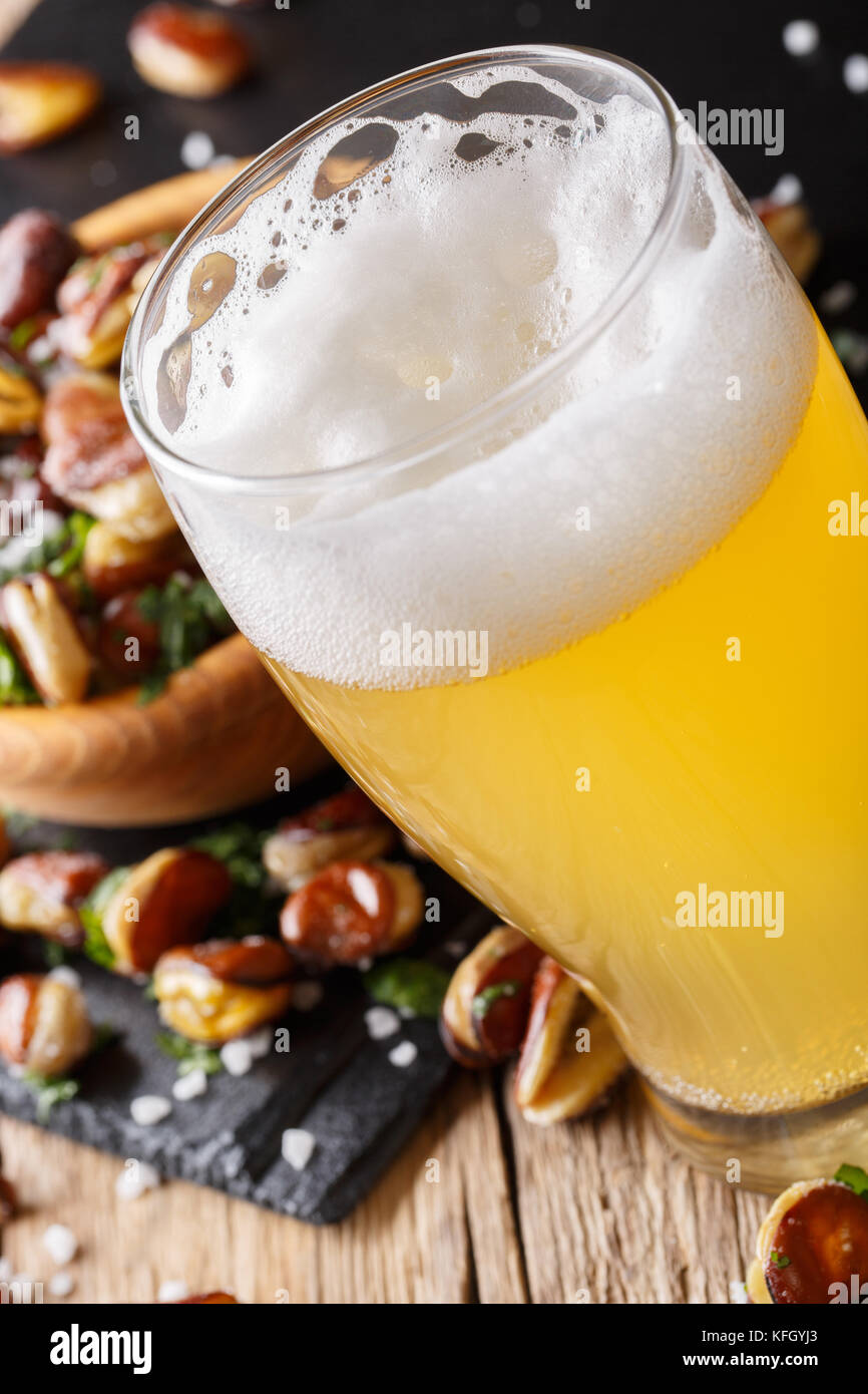 Bicchiere di birra chiara con uno spuntino a base di fagioli fritti vicino sul piano verticale. Foto Stock