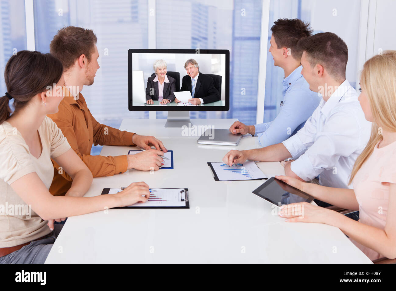 I giovani uomini di affari che guardando il monitor di computer in sala conferenze Foto Stock