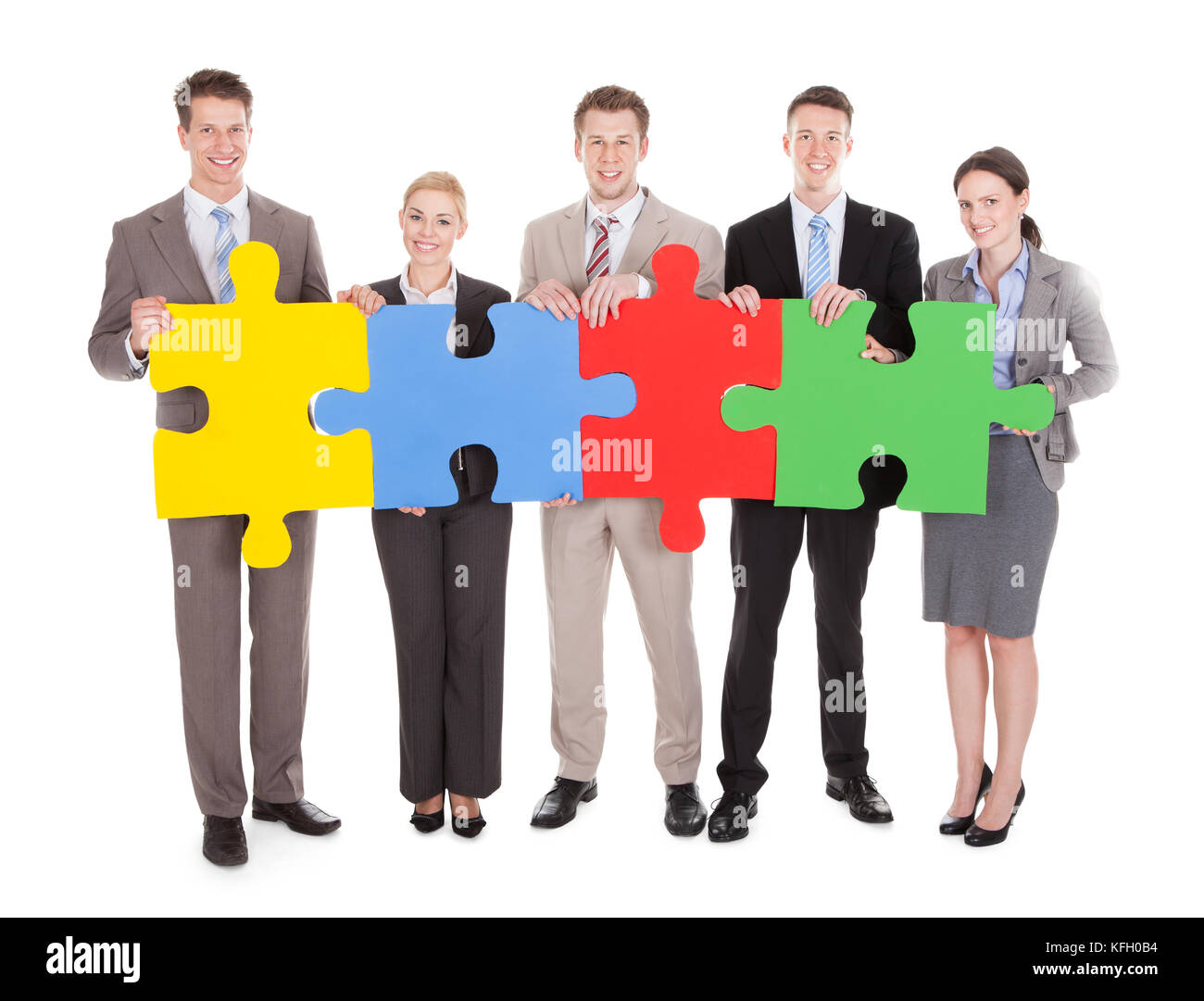A piena lunghezza Ritratto di certi giovani persone azienda colorato puzzle su sfondo bianco isolato Foto Stock