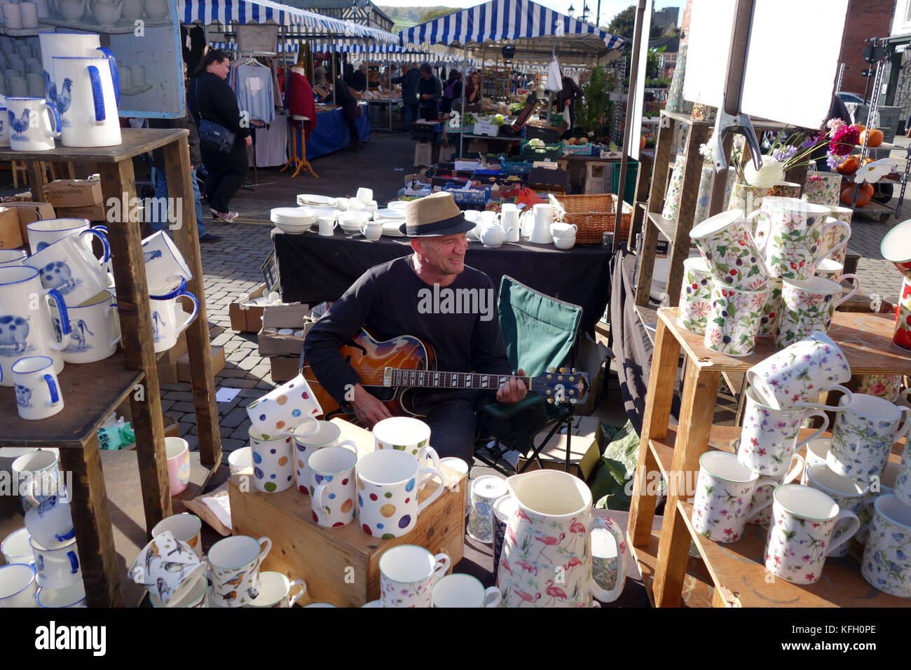 Mercato stallholder suonando la chitarra a Ludlow Mercato in Shropshire Regno Unito Foto Stock