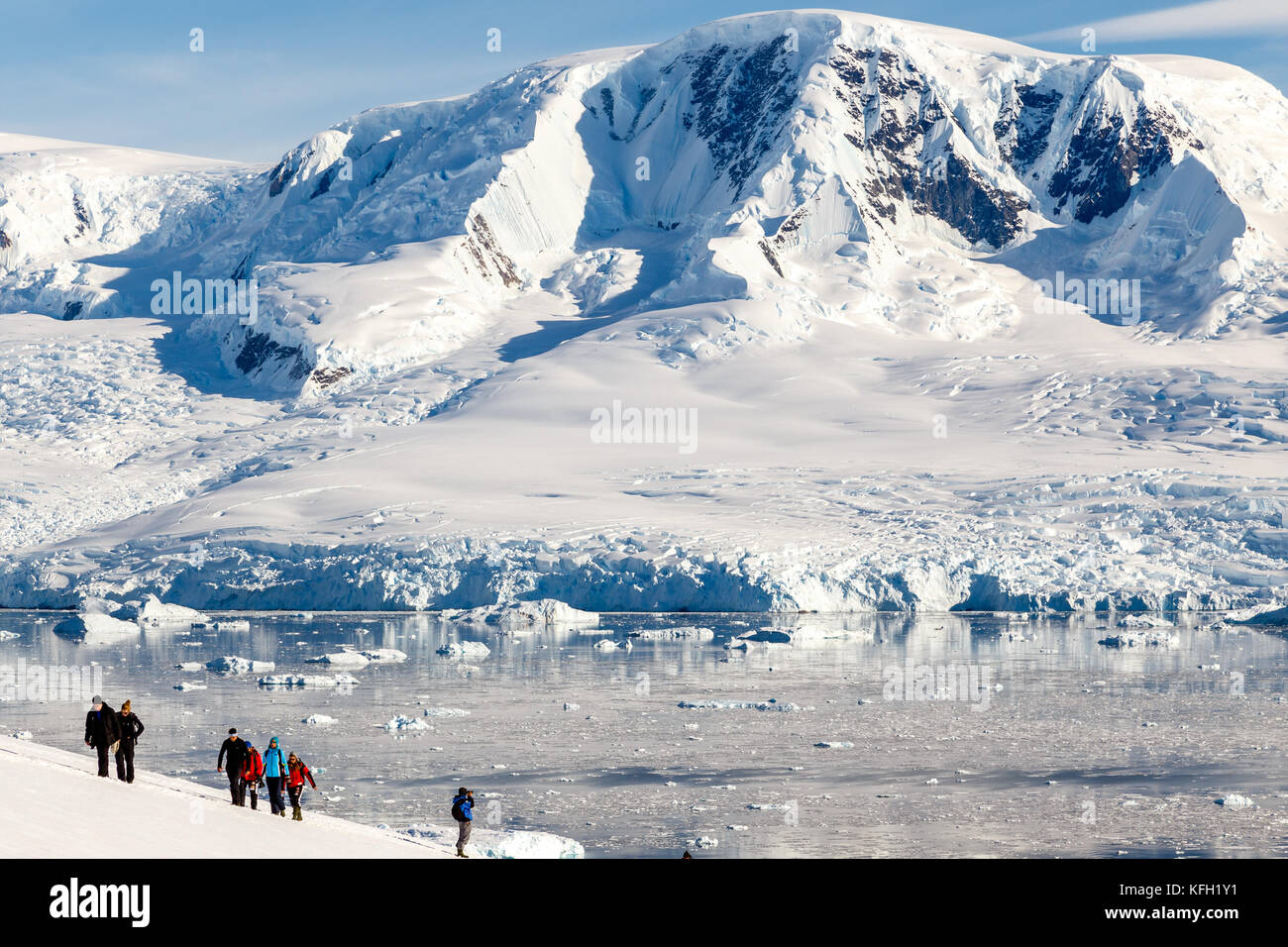 Gruppo di persone escursioni sulle montagne innevate con ghiacciaio in background, Neko bay, Antartico Foto Stock