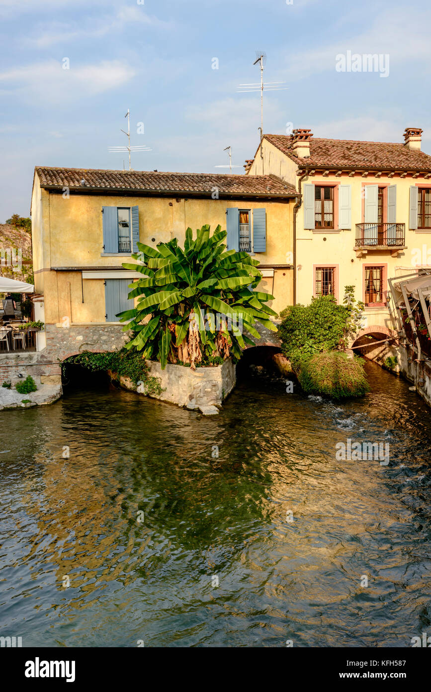 Vista di vecchie case pittoresche oltre il fiume Mincio, girato in caduta luminosa luce a Valeggio, Verona, veneto, Italia Foto Stock