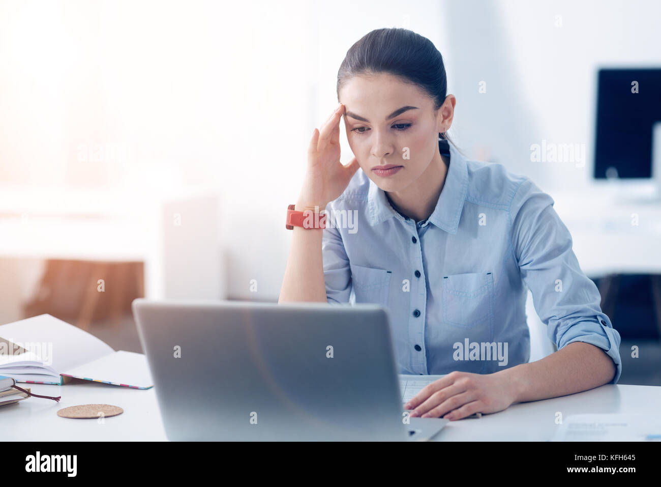 Stanco femmina di un dipendente che lavora sul computer portatile in ufficio Foto Stock