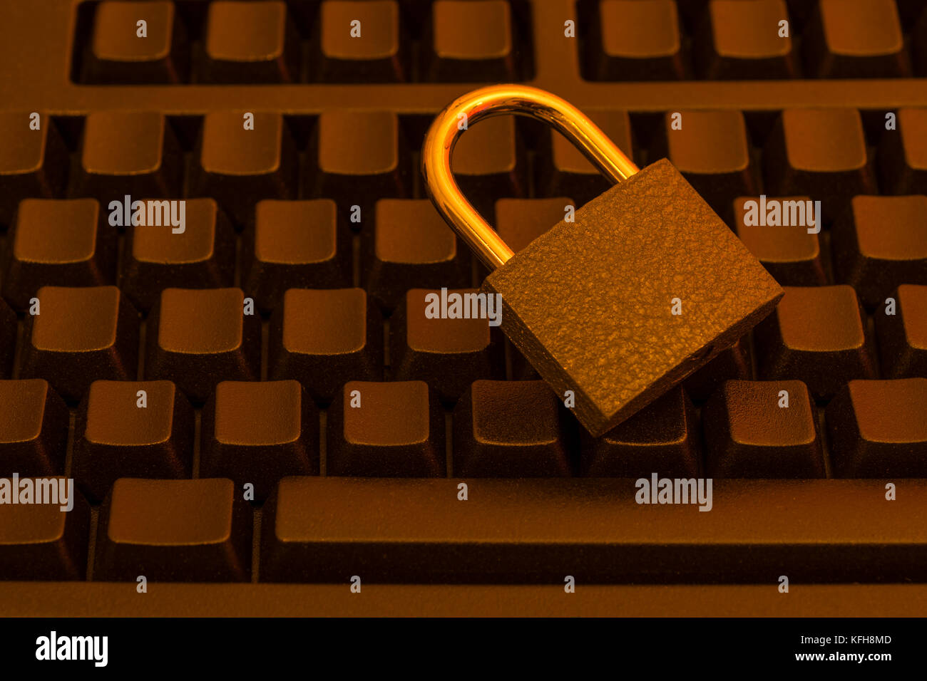 Piccolo lucchetto su una tastiera nera, per minacce informatiche, sicurezza informatica, sicurezza dei dati e delle e-mail, privacy delle e-mail e concetto di login sicuro. Foto Stock