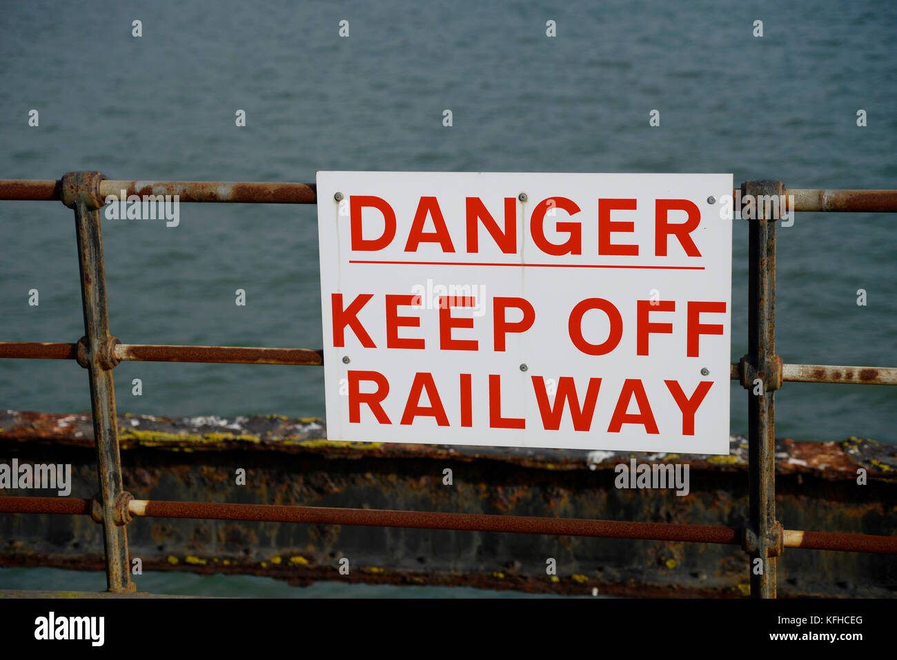 Cartello di avvertimento Southend Pier Railway, pericolo tenere lontano dalla ferrovia sulle ringhiere. Corrosione Foto Stock