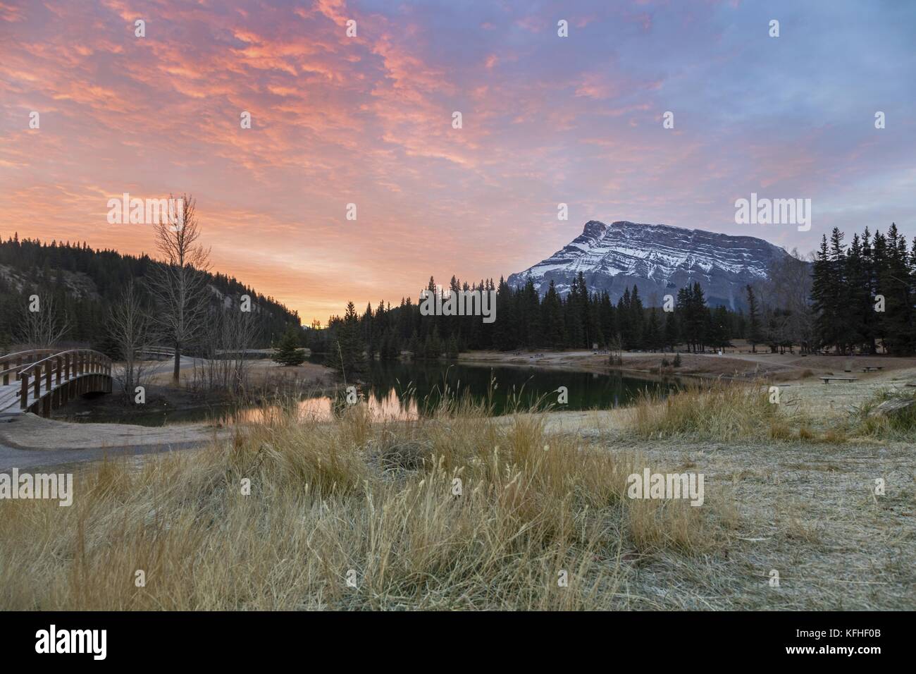 Sunrise Sky, Prairie Grassland, Lake o Pond e Rundle Mountain Peak Landscape. Banff National Park, Rocky Mountains, Alberta Foothills, Canada Foto Stock