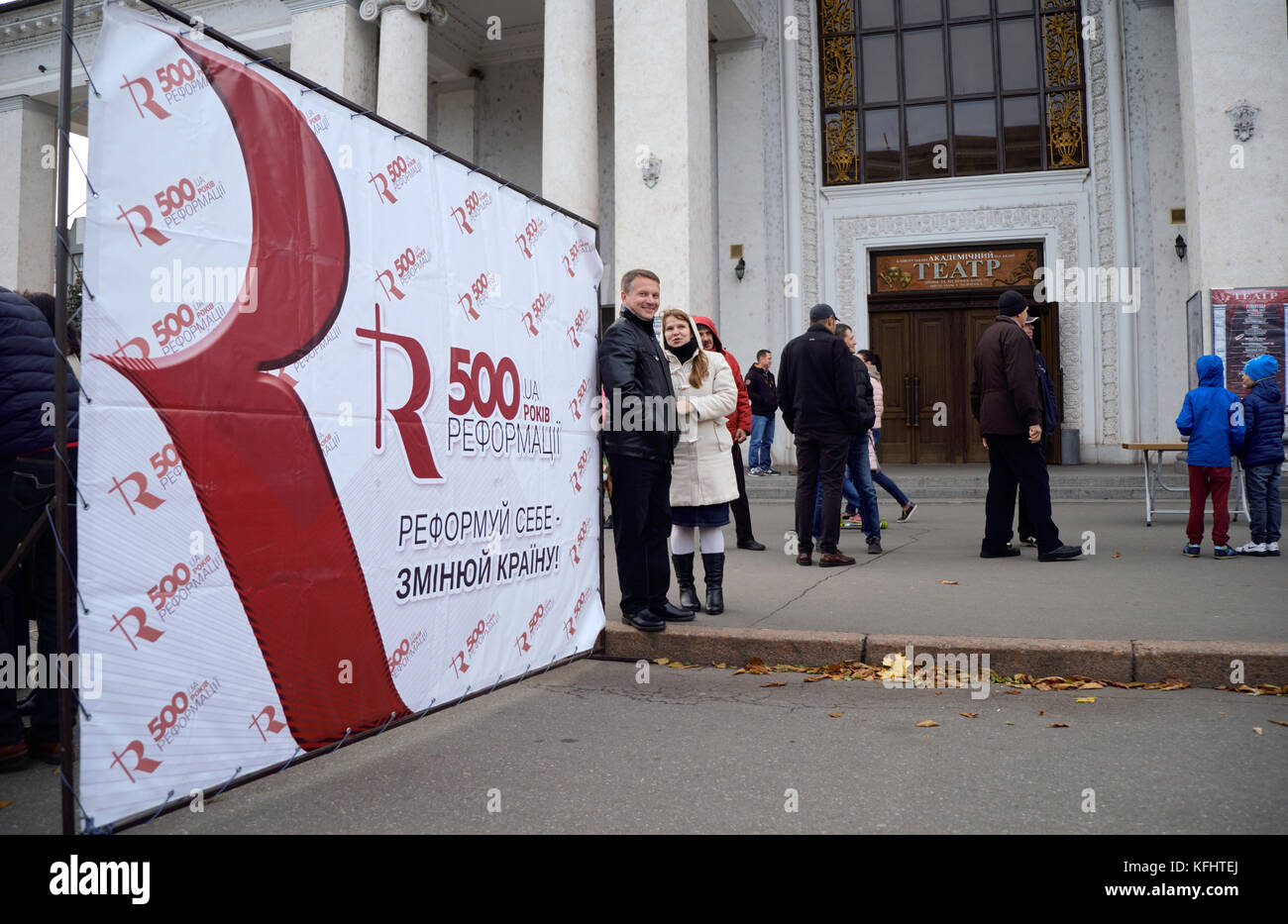 Kryvyi Rih, ucraina. 29 ottobre, 2017. persone accanto al poster sulla strada di fronte di Kryvyi Rih teatro accademico a evento dedicato alla riforma cinquecentesimo anniversario credito: dmytro aliokhin/alamy live news Foto Stock