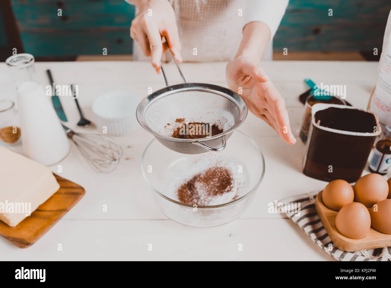 Casa moglie indossando il grembiule rendendo. fasi di realizzare la cottura di una torta al cioccolato. Foto Stock