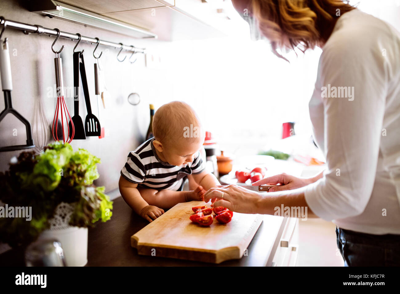 Giovane madre con un bimbo a fare i lavori di casa. Foto Stock