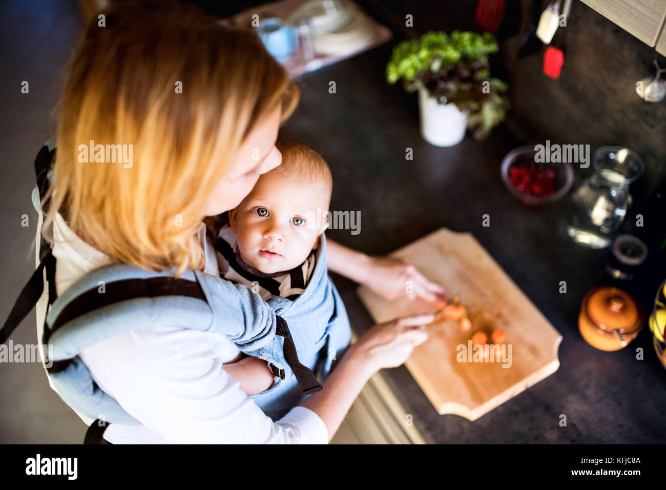 Giovane madre con un bimbo a fare i lavori di casa. Foto Stock