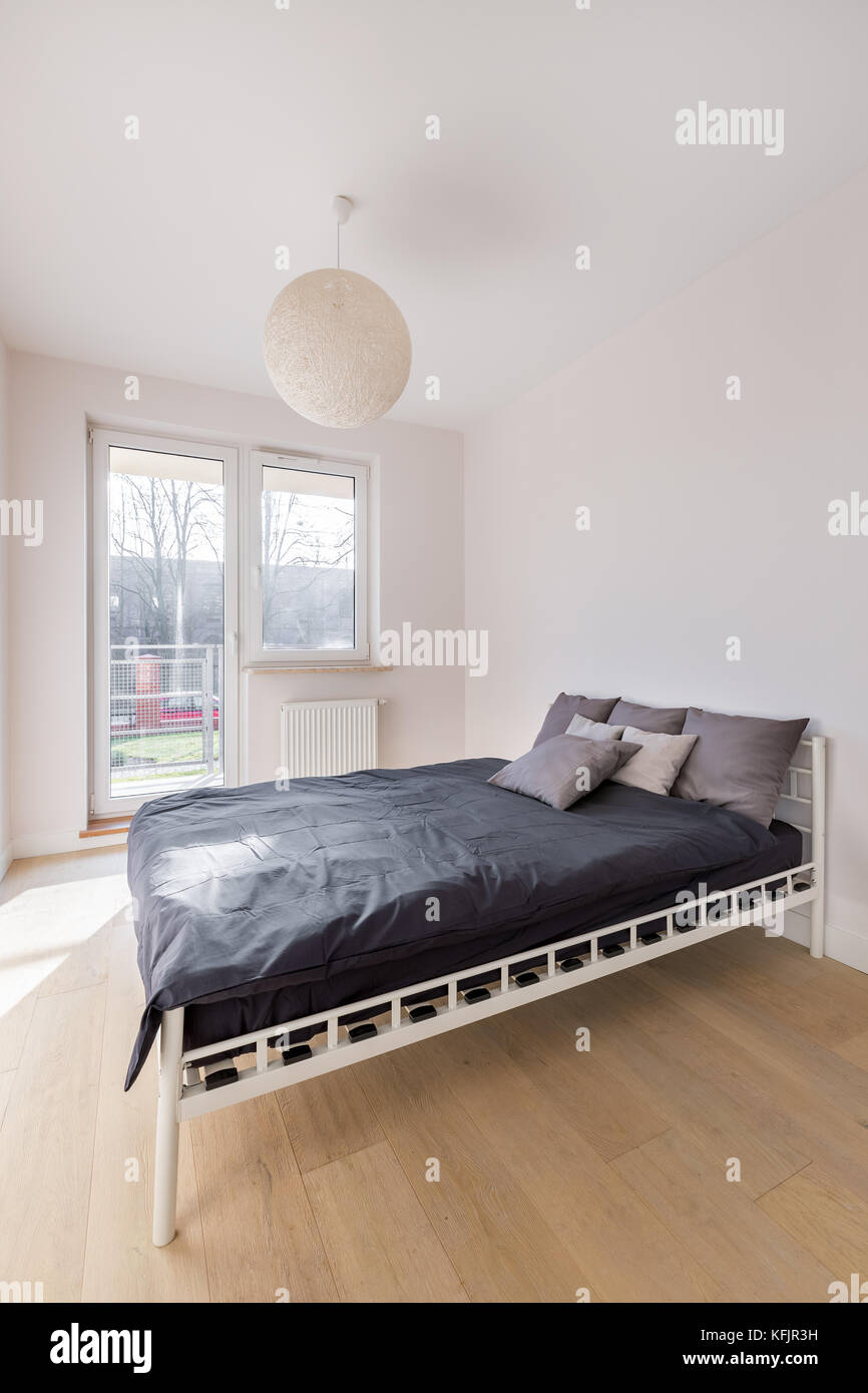 Camera da letto bianco con cotone palla lampada, letto matrimoniale e  balcone Foto stock - Alamy