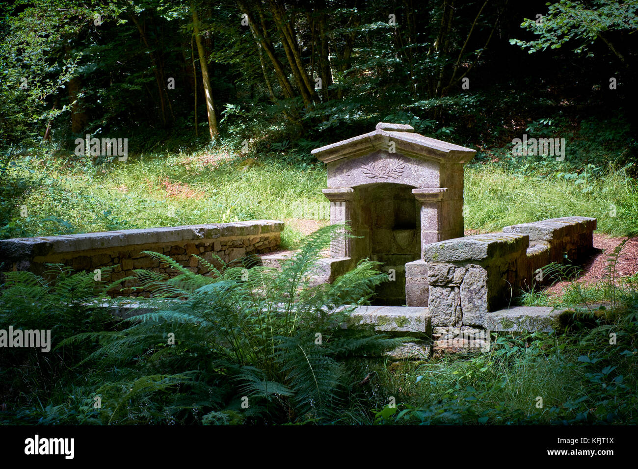 Una fonte romana di acqua potabile in una glade boscosa nel Pays Bigouden vicino al fiume Odet Finistere Bretagna Francia. Foto Stock