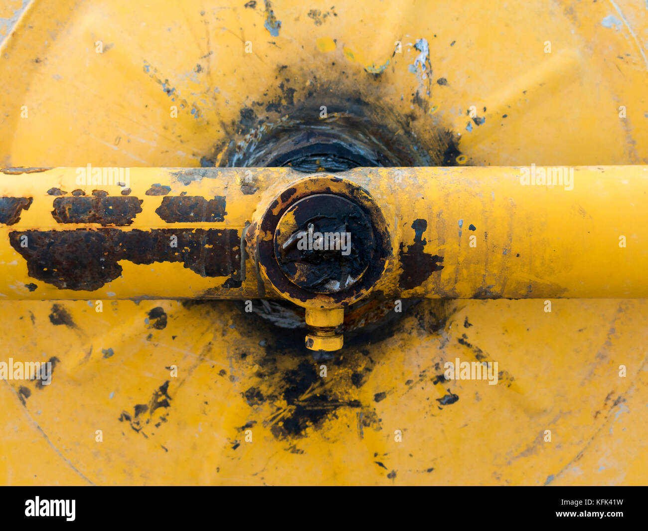Dettaglio meccanico di un vecchio giallo mescolatore di cemento sporco di grasso Foto Stock