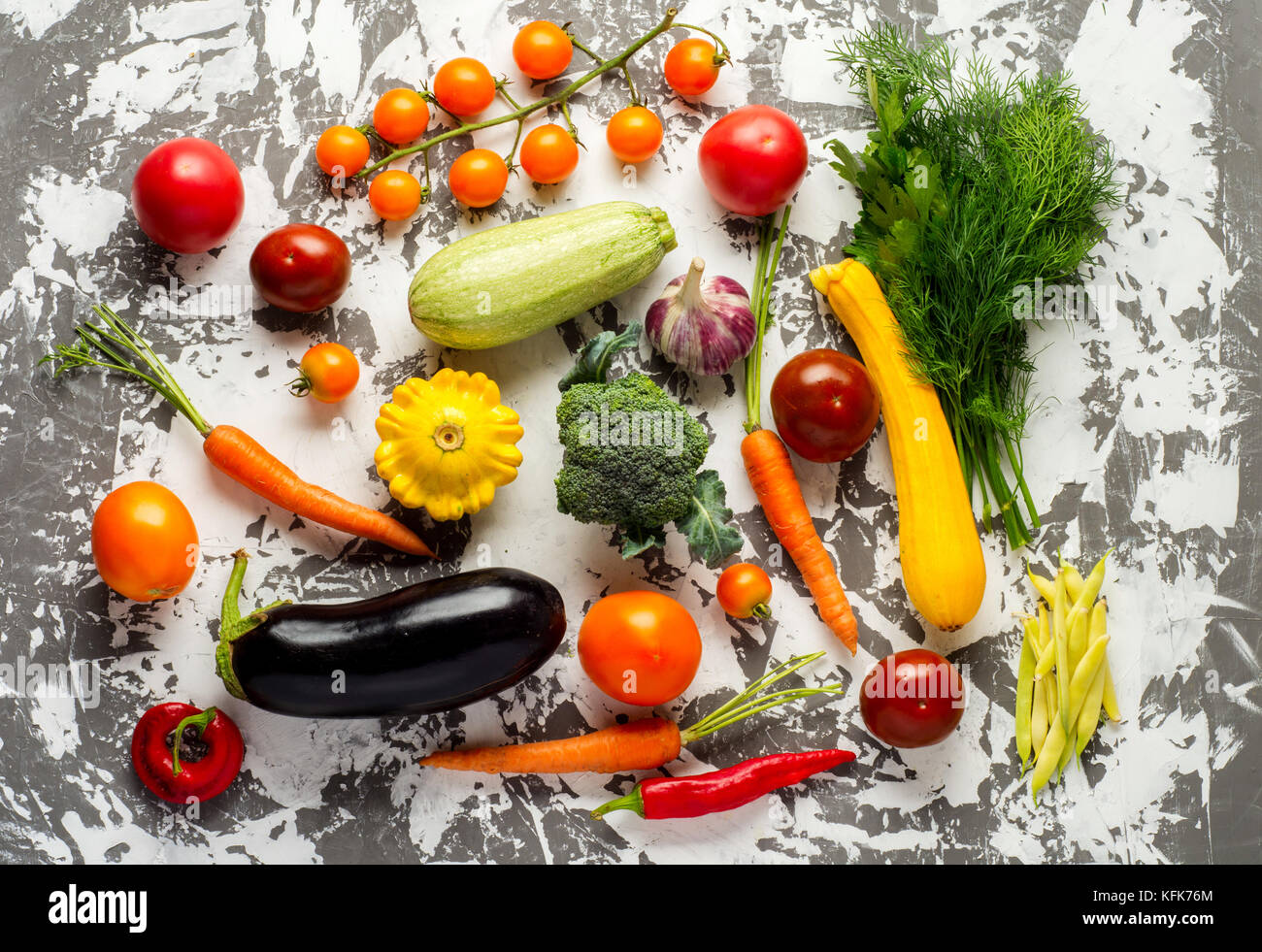 Materie verdure organiche con ingredienti freschi per cucinare in modo sano su calcestruzzo sfondo, vista dall'alto, banner. vegan o dieta alimenti concetto. Foto Stock