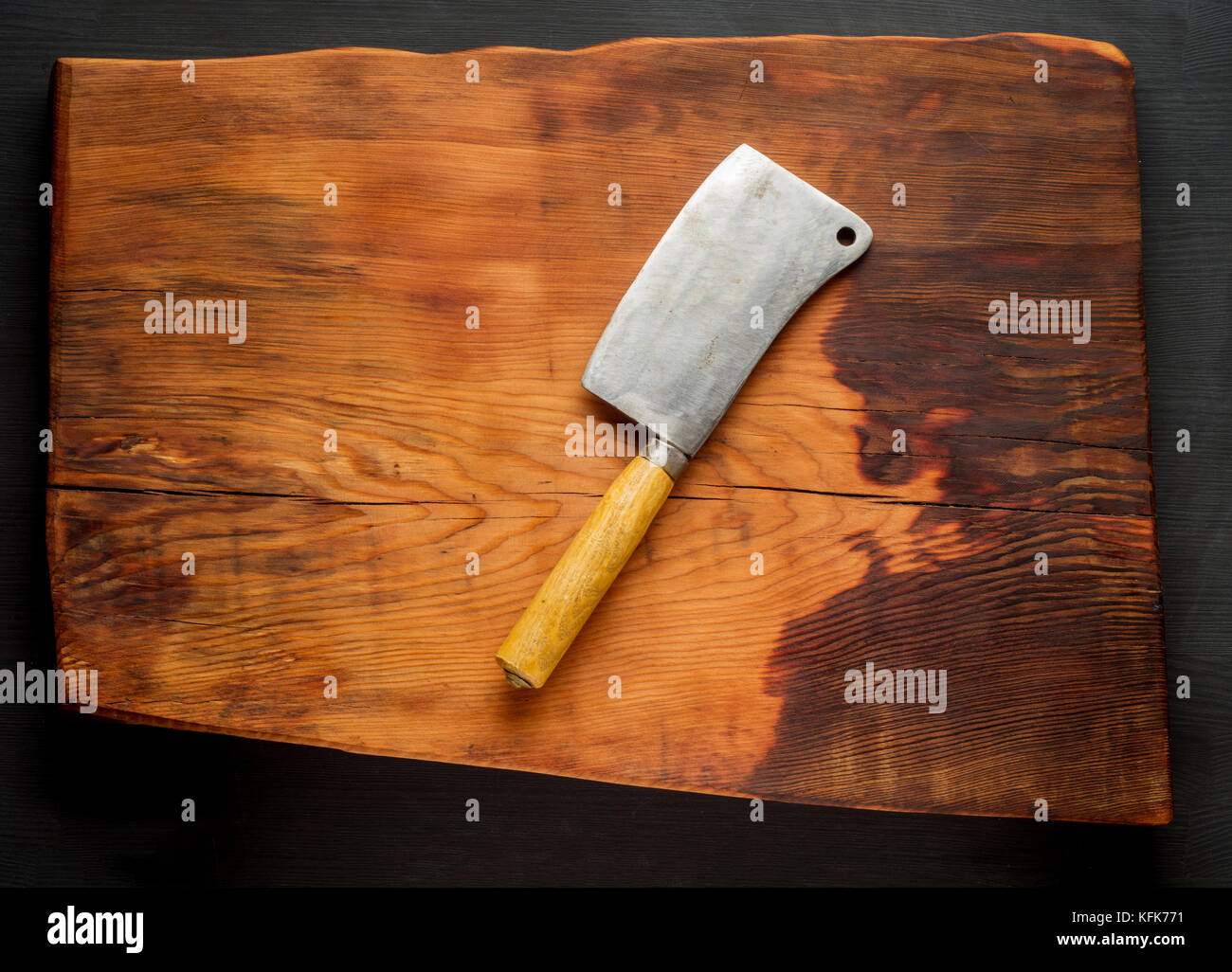 Butcher. vintage macellaio cleavers carne sul legno scuro scheda cucina dello sfondo. Foto Stock