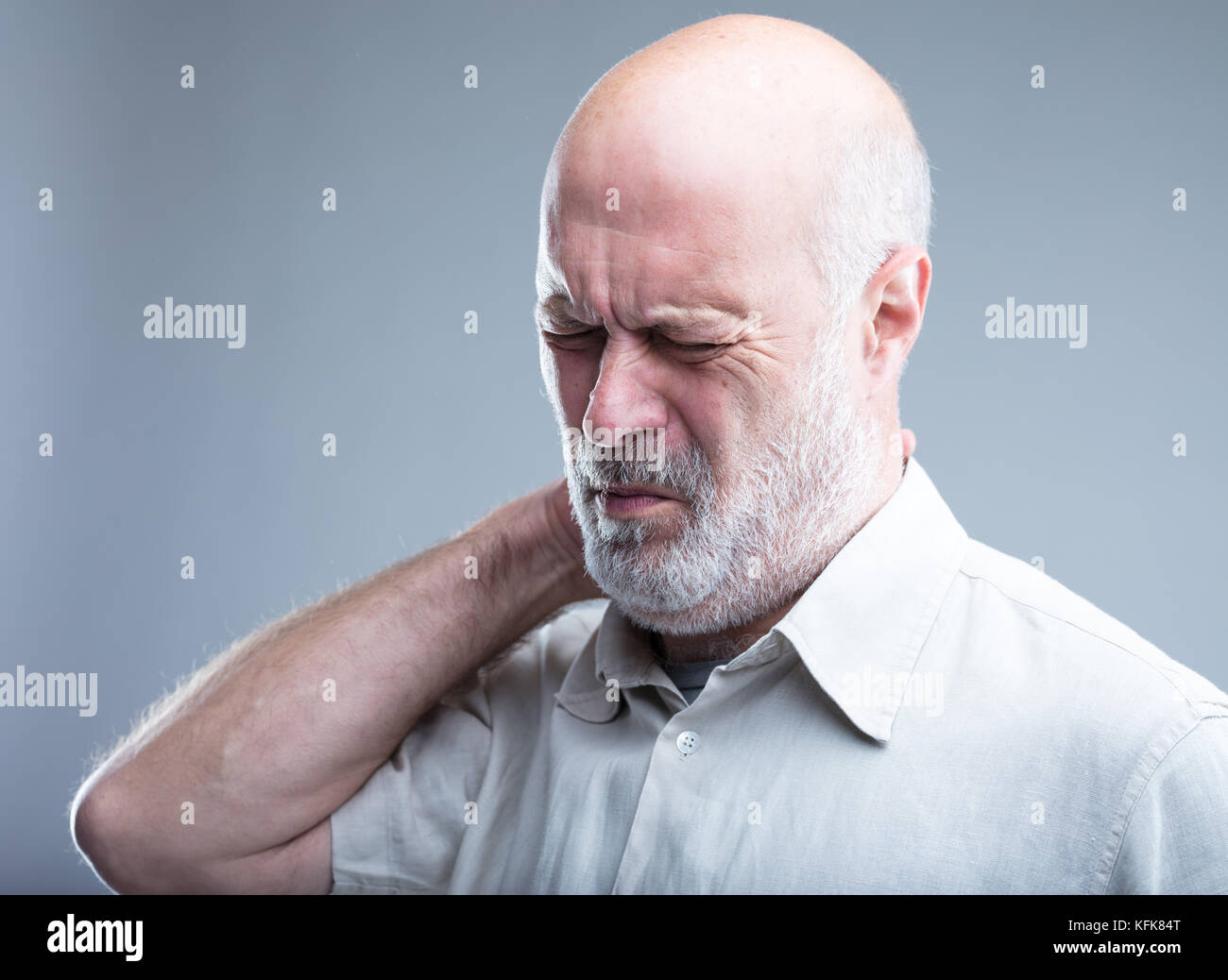 Il dolore al collo di un vecchio uomo potrebbe essere un mal di testa o mal di schiena Foto Stock