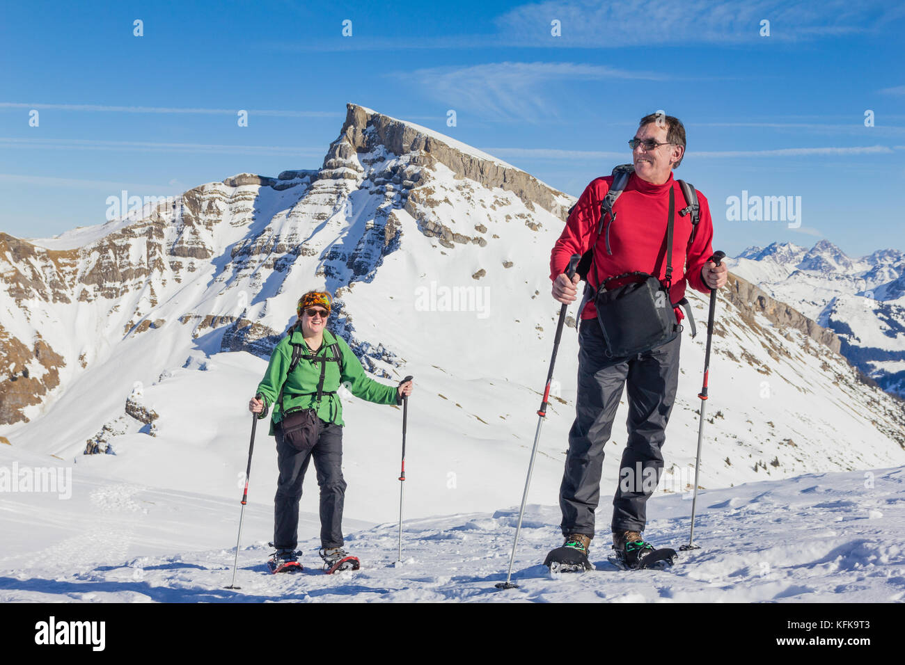 Coppia senior è escursioni con racchette da neve in inverno alpino montagne. La Baviera, Germania. Foto Stock