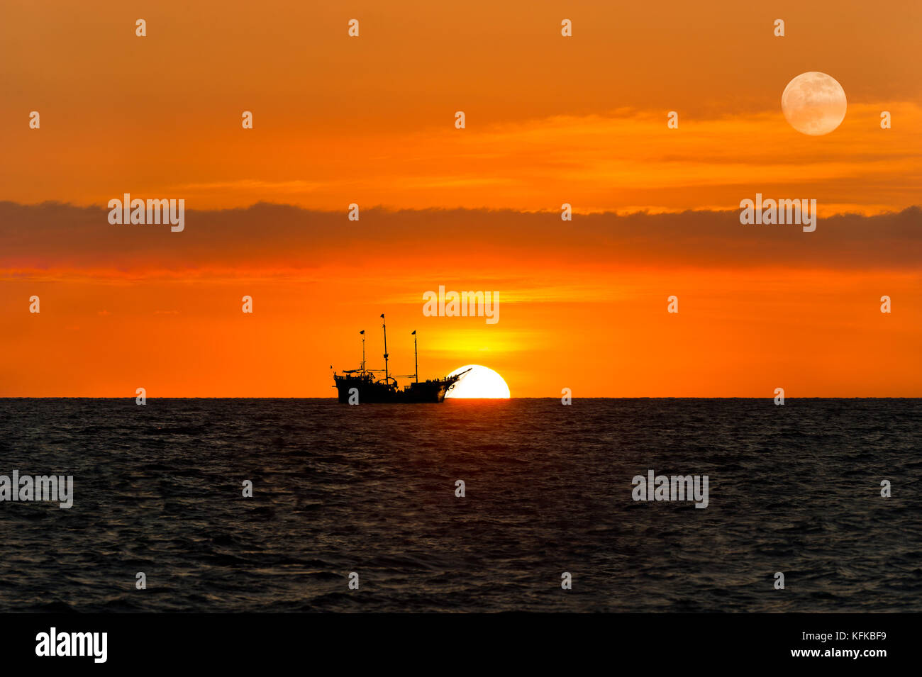 Nave Pirata silhouette è una nave pirata seduta sul mare guardando il tramonto sull'oceano come la luna sorge nel cielo. Foto Stock