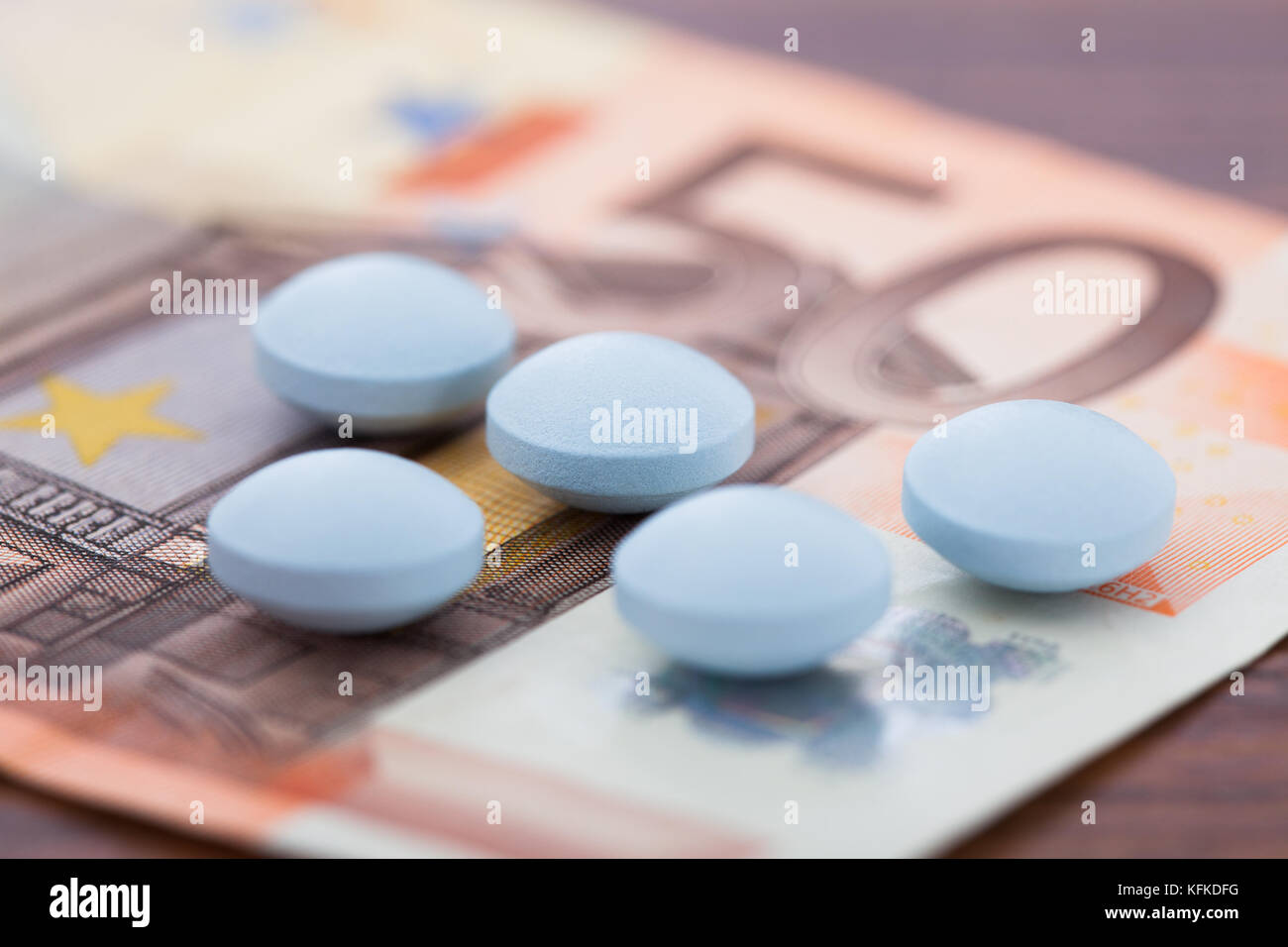 Primo piano di pillole giacente su di banconote in euro Foto Stock
