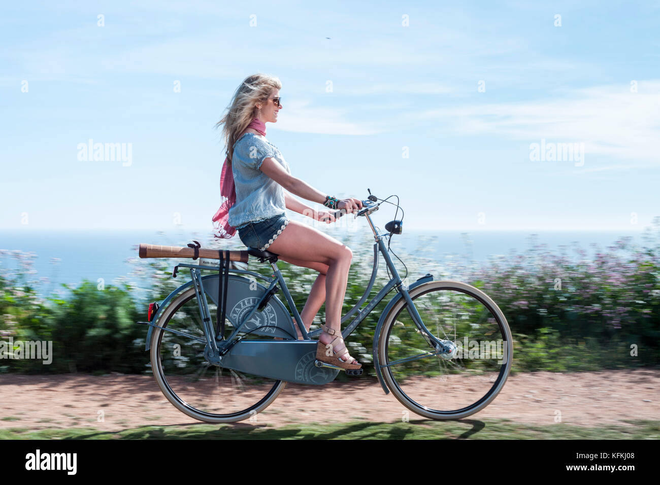 Los Angeles, CA - 11 luglio: La donna corse in bicicletta su un percorso che affacciano sull'oceano a los angeles, la California il 30 marzo 2011. Foto Stock
