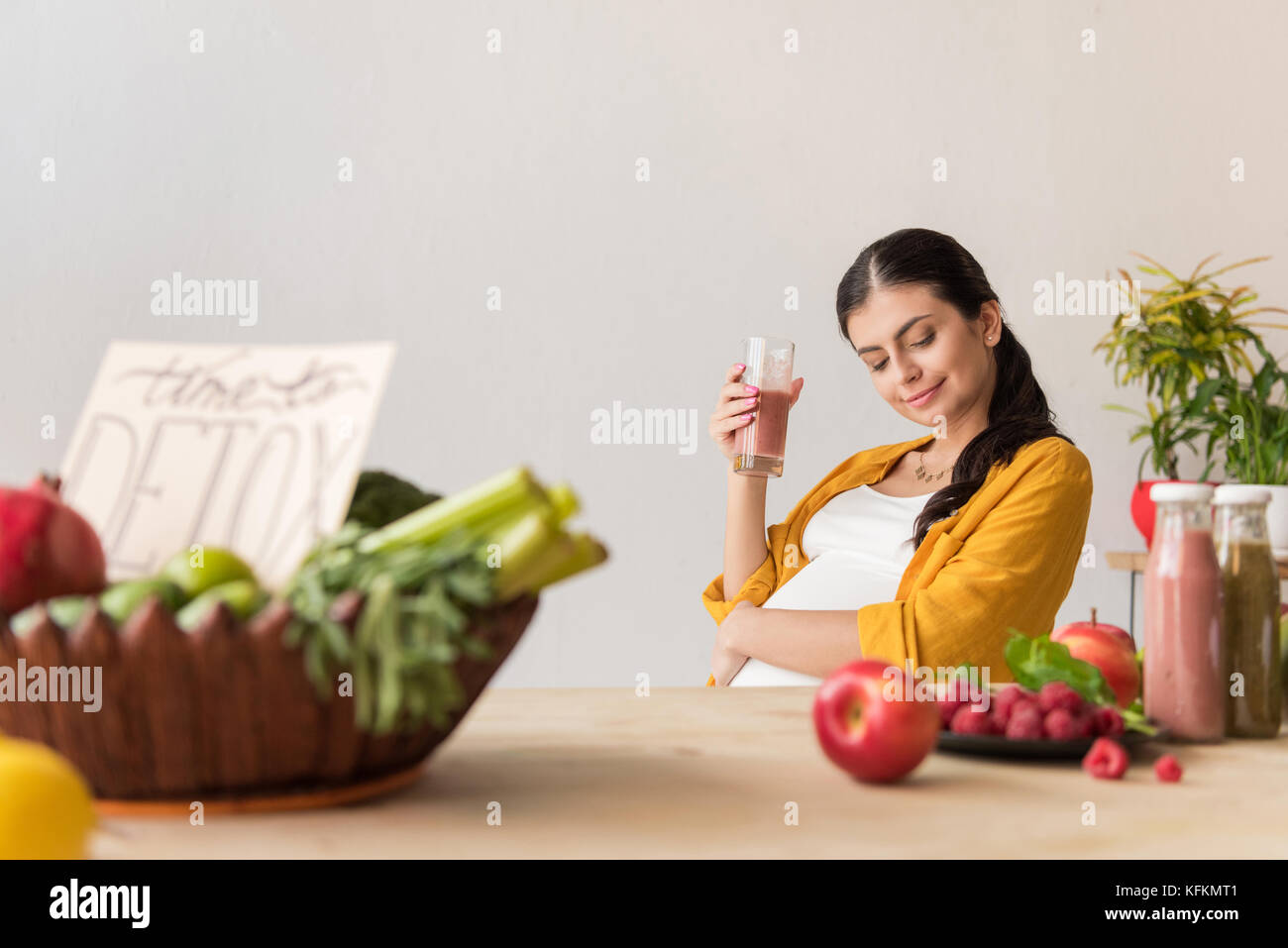 Donna incinta con detox drink in mano Foto Stock